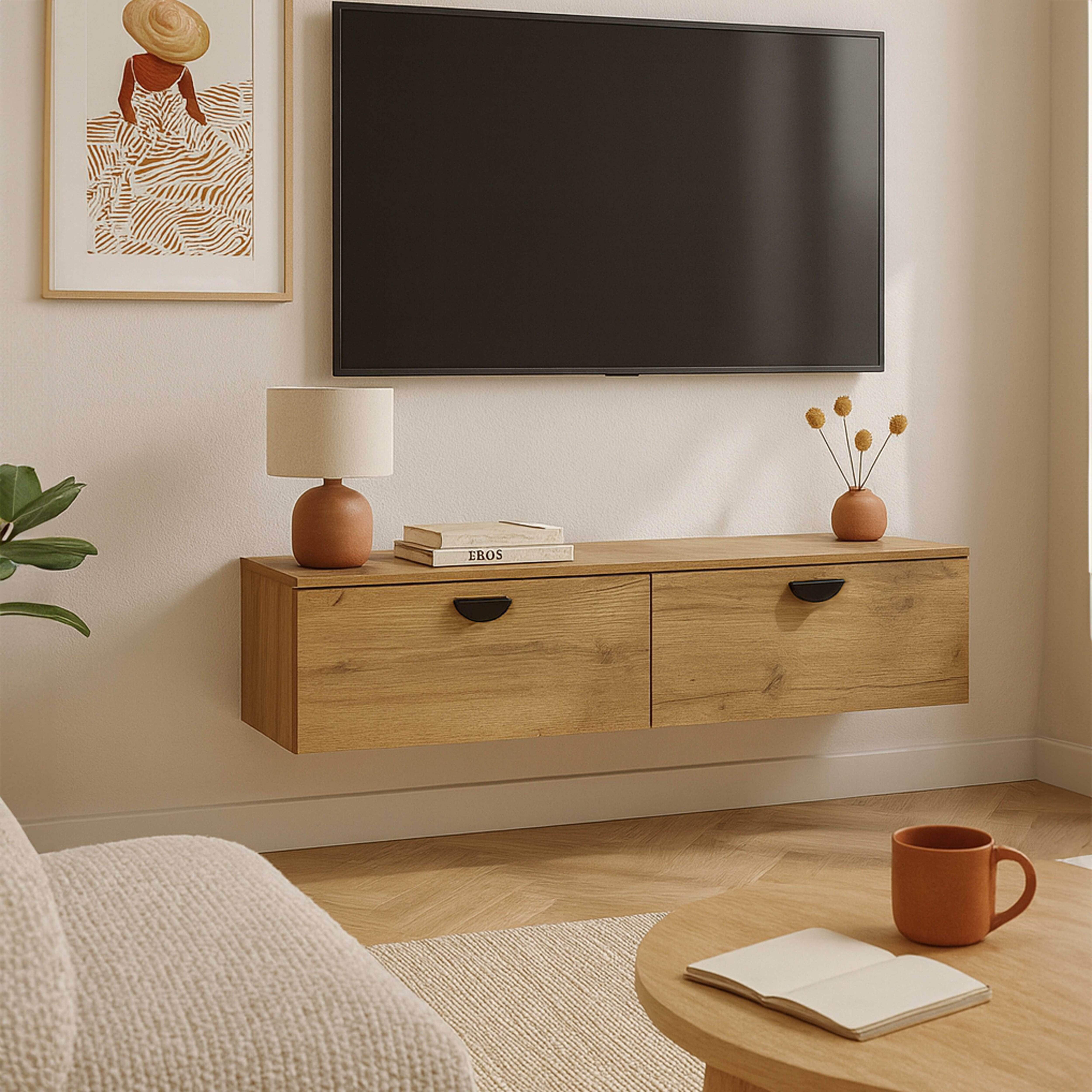 Ein Wohnzimmer mit Fernseher, Holzschrank, Gemälde und Couchtisch mit Tasse und Buch.