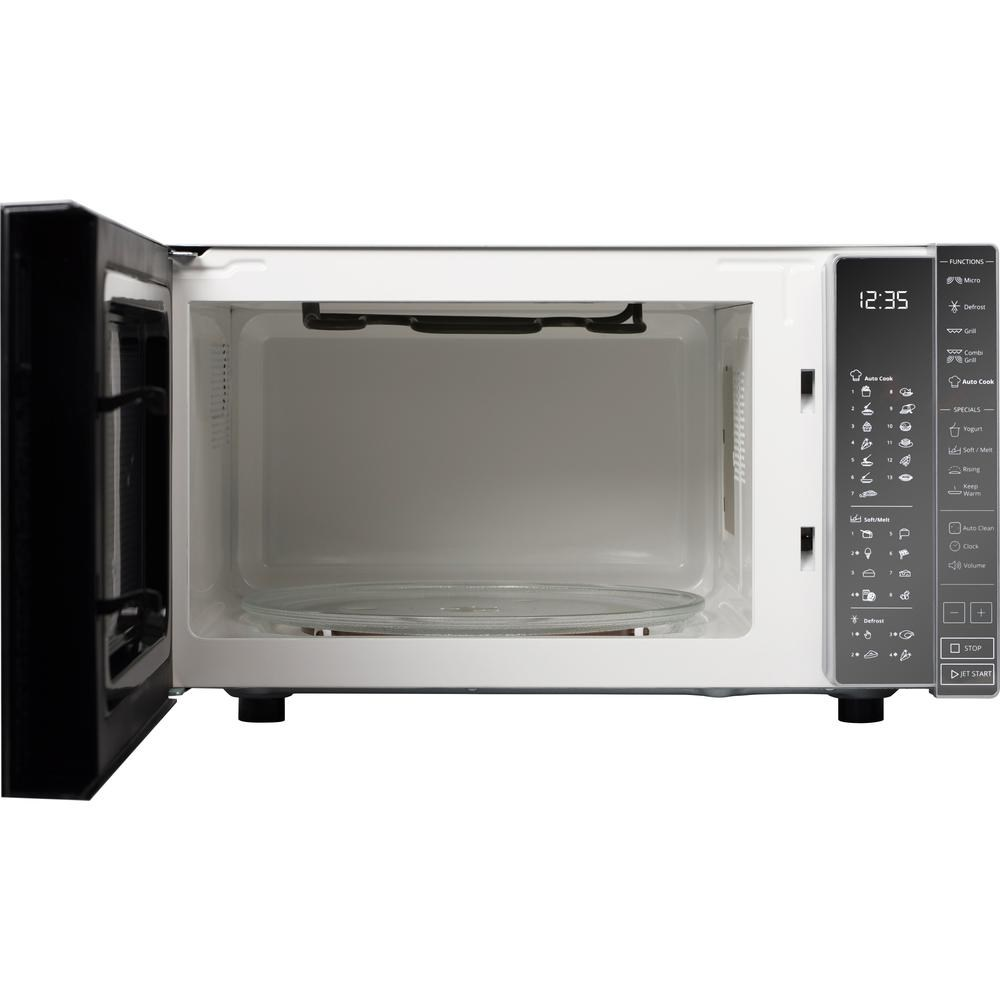 Un forno a microonde aperto con un piatto di vetro all'interno. La porta è aperta. Il display digitale mostra 12:35. Pannello di controllo a destra.