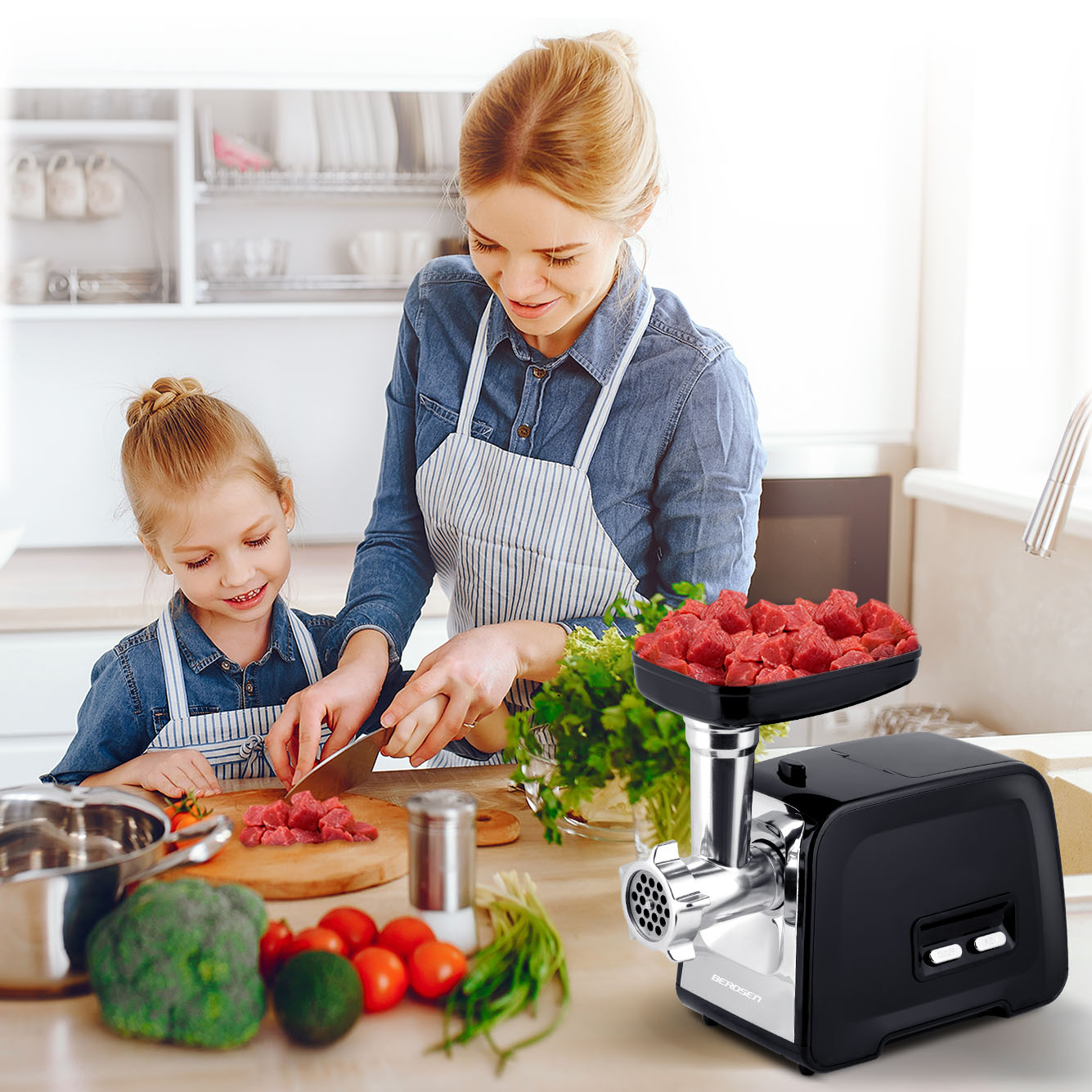 Kobieta i dziewczynka kroją mięso na drewnianej desce. Po prawej stronie maszynka do mięsa. Warzywa na stole.