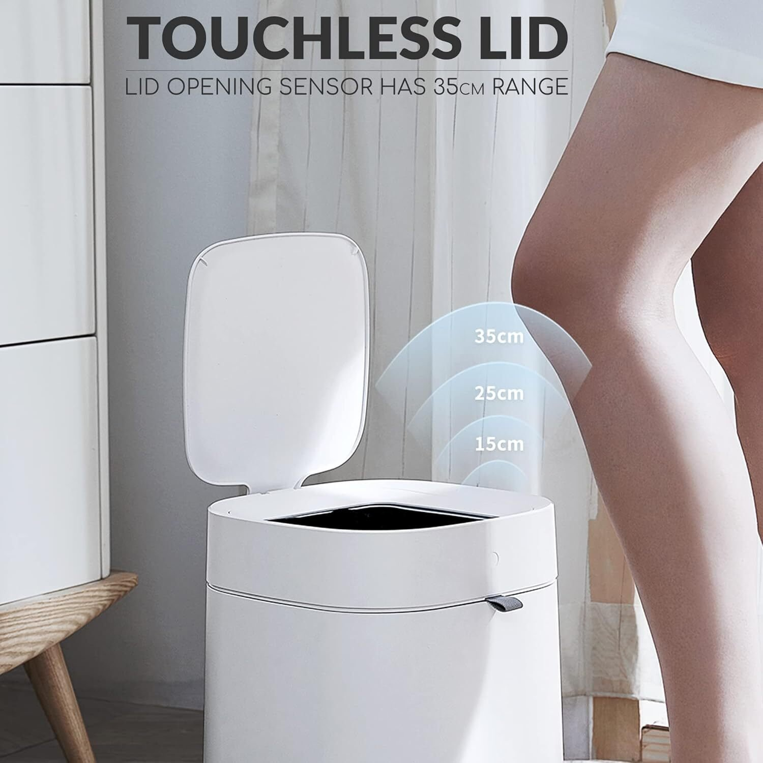 Un basurero blanco sin contacto con tapa abierta. La tapa se abre automáticamente. Indicadores de alcance 35cm, 25cm y 15cm presentes.