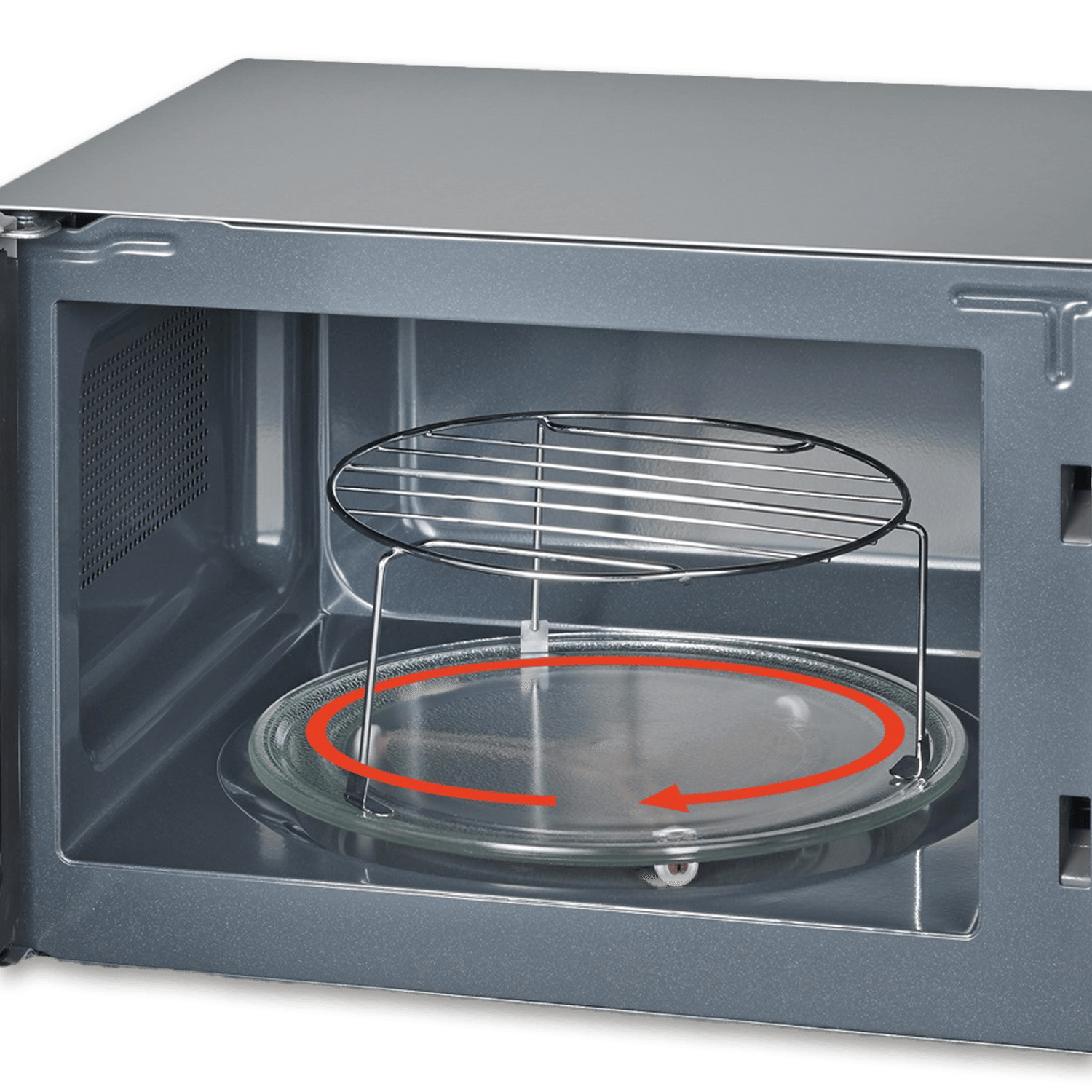 Wnętrze kuchenki mikrofalowej. Szklany talerz z czerwoną strzałką wskazującą obrót. Metalowy ruszt nad nim. Drzwi otwarte.