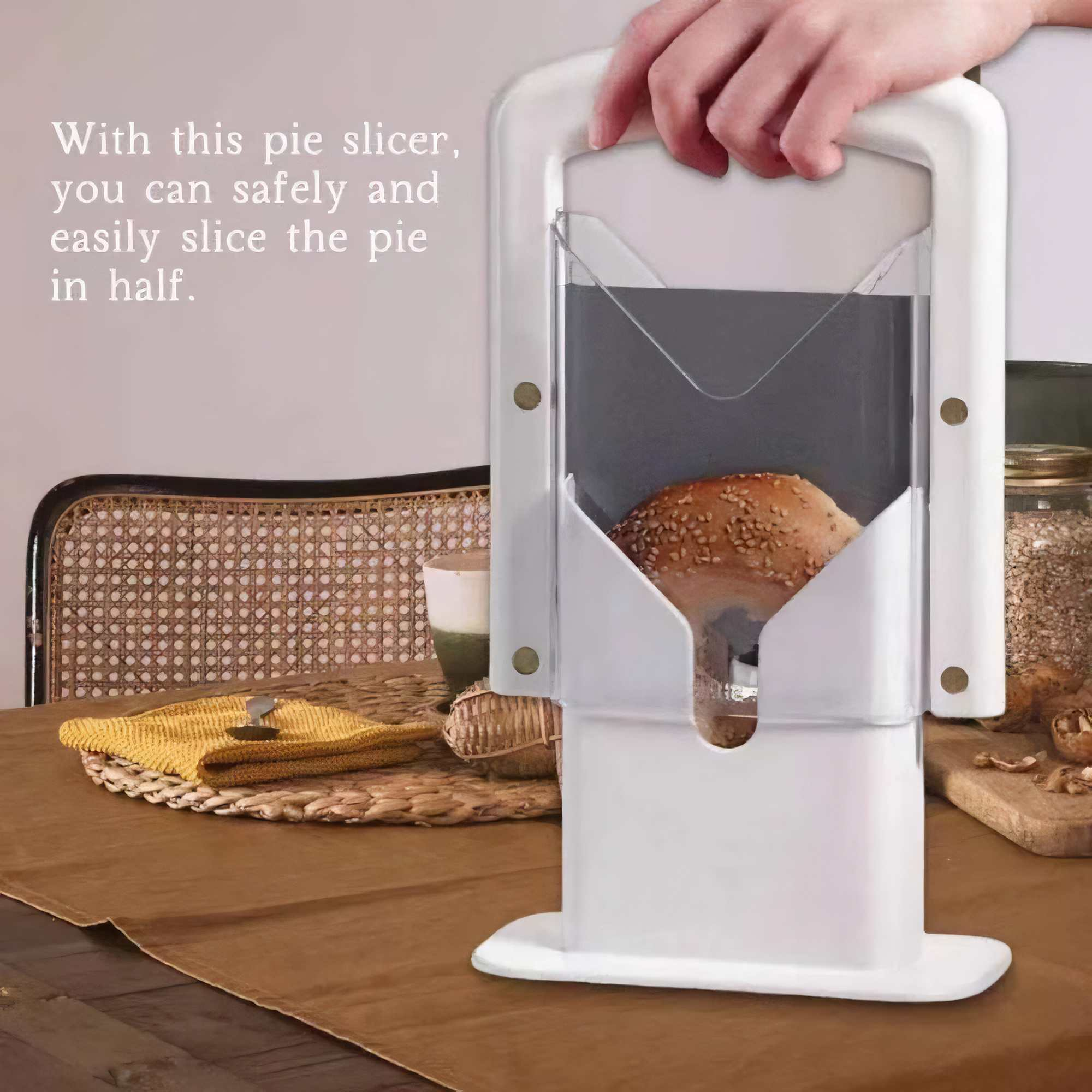 Ein weißer Tortenschneider wird über einem Kuchen gehalten. Eine Hand hält den Schneider. Ein Tisch ist gedeckt.