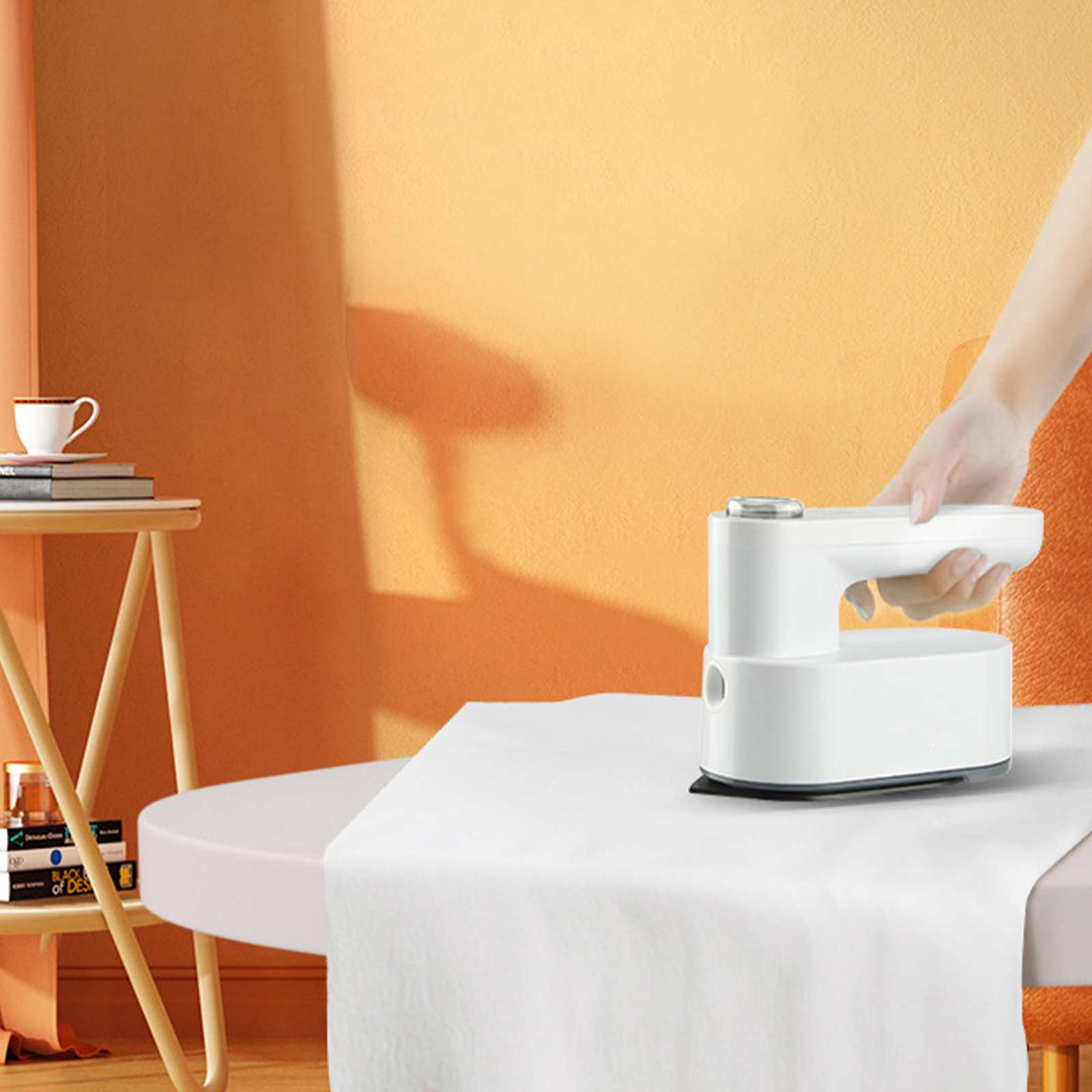 Ein weißes Bügeleisen wird auf einem weißen Tuch verwendet. Der Hintergrund zeigt einen Tisch mit einer Tasse und orangefarbenen Wänden.