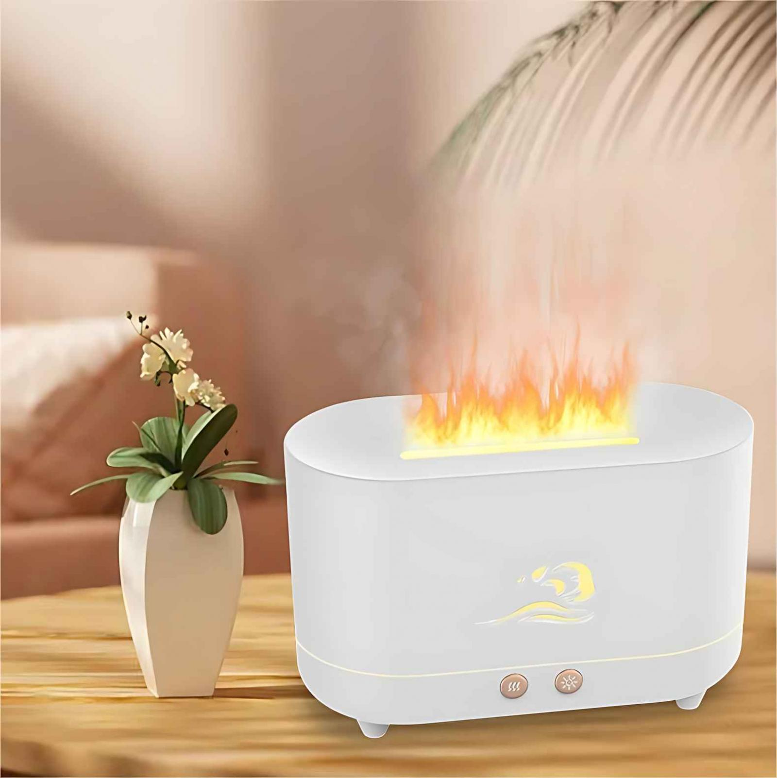 Ein weißer Luftbefeuchter mit Flammeneffekt steht auf einem Tisch. Links steht eine Vase mit Blumen. Der Hintergrund ist unscharf.