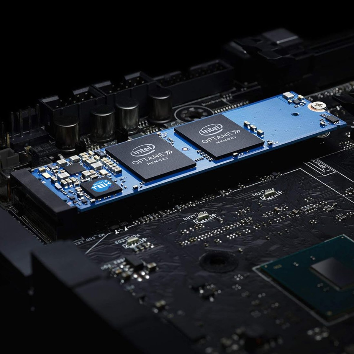 Un primo piano di un circuito stampato per computer. Un componente blu con due chip Intel Optane al centro. Lo sfondo è scuro.