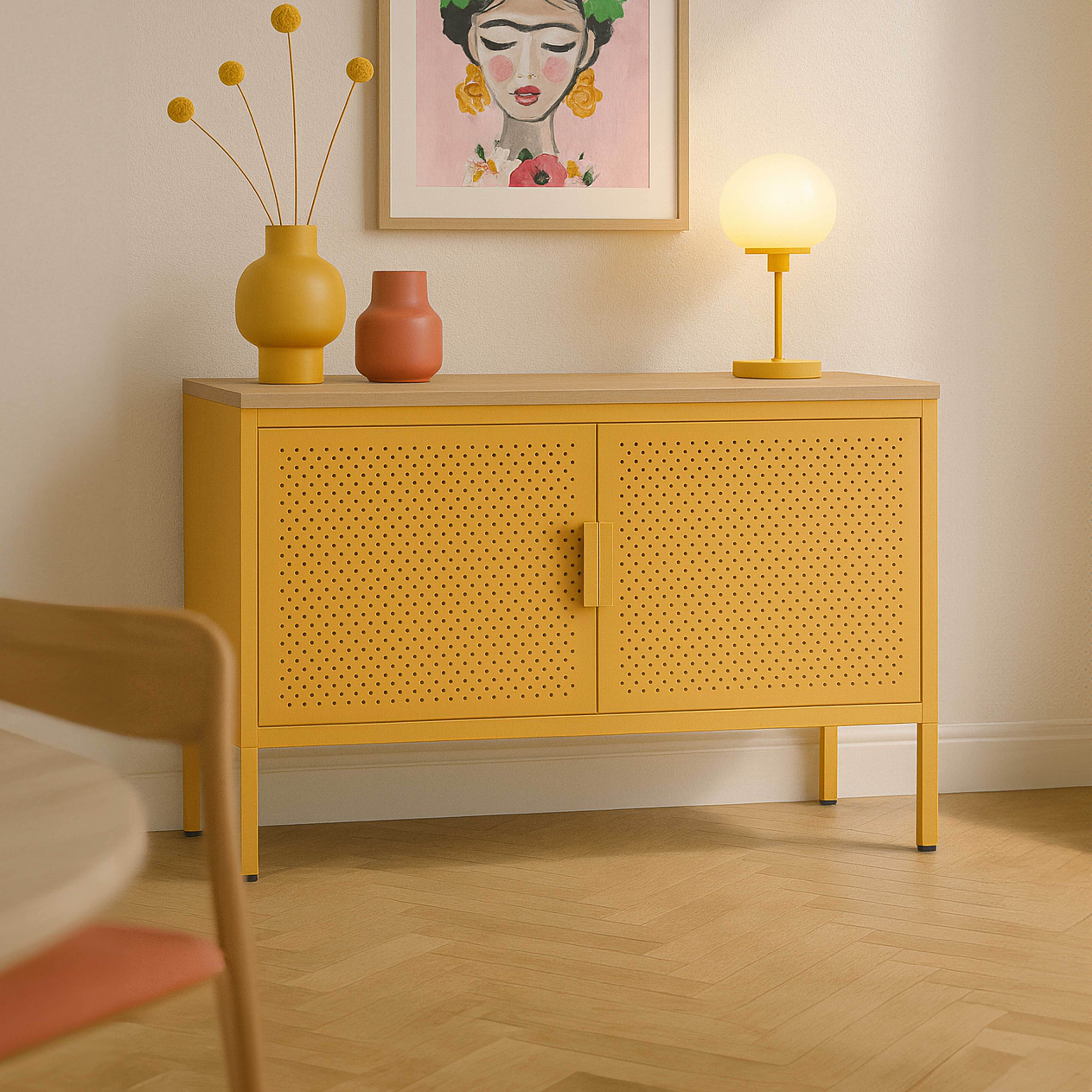 Gelber Schrank mit Kunst, Lampe und Vasen. Ein Holzstuhl und Boden sind im Vordergrund.