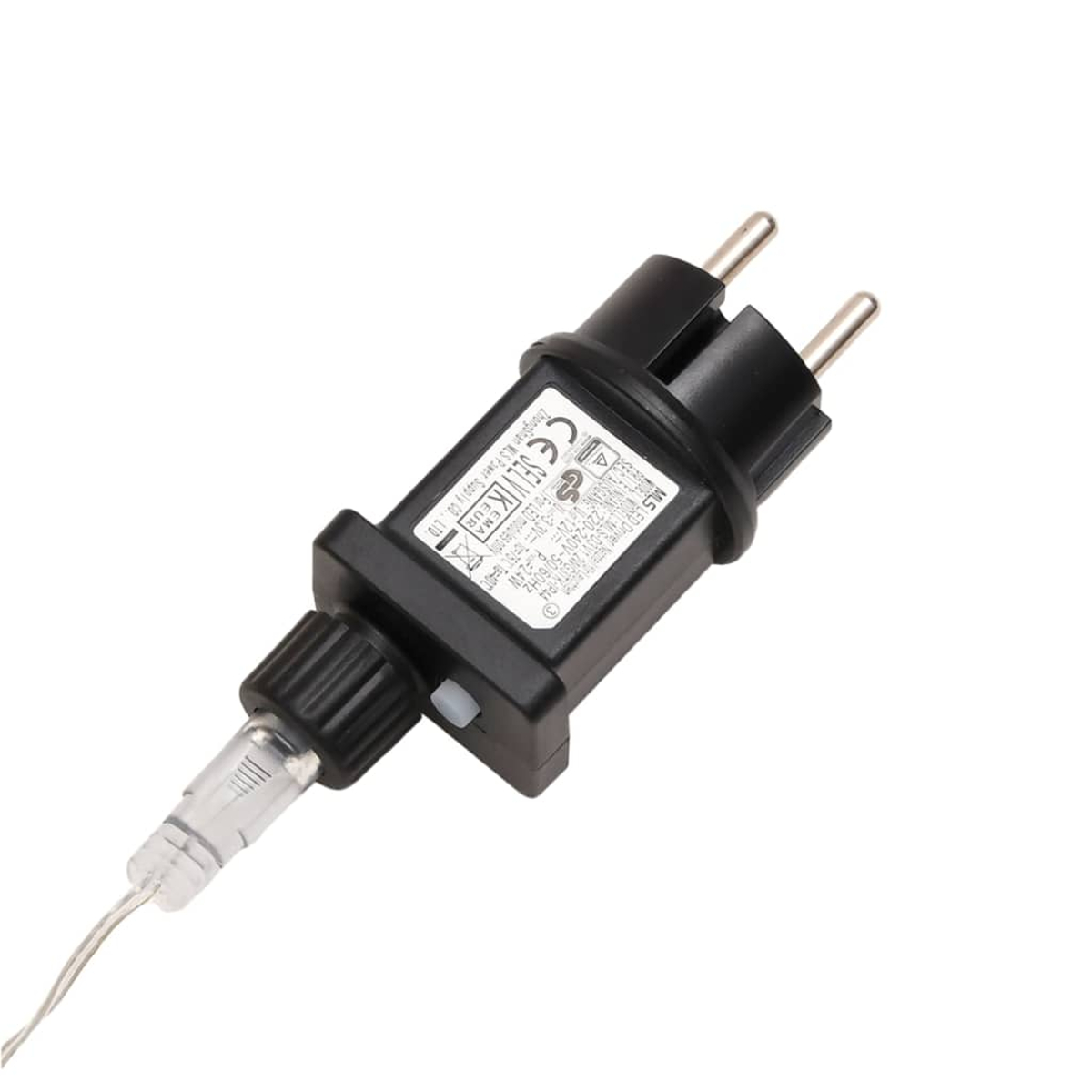 Schwarzer Netzadapter mit zwei Stiften, einem kleinen weißen Knopf und einem durchsichtigen Kunststoffstecker an einem Draht, vor weißem Hintergrund.