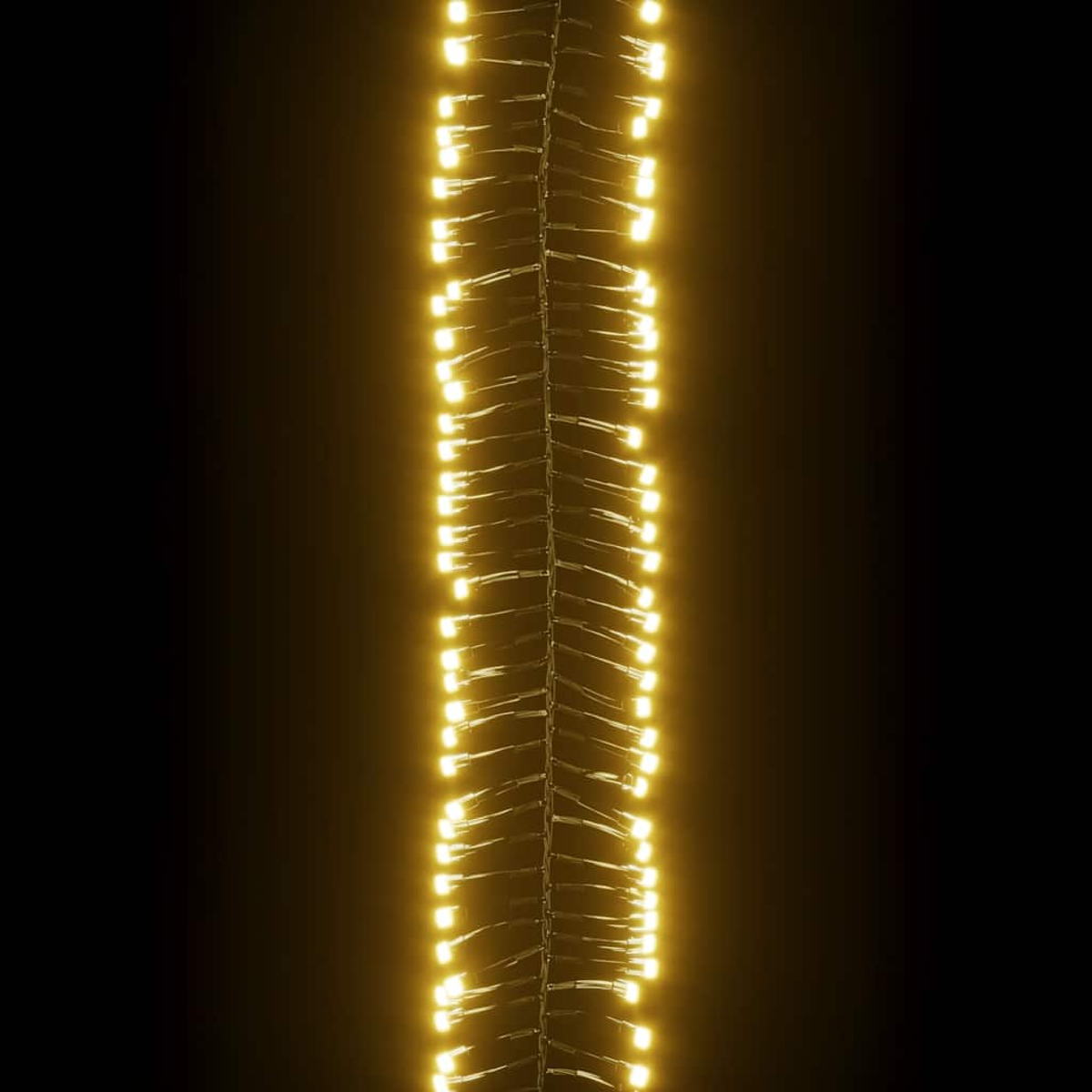 Vertikale Lichterkette mit warmweißen LEDs vor schwarzem Hintergrund. Die Lichter sind eng beieinander und bilden eine leuchtende Säule.