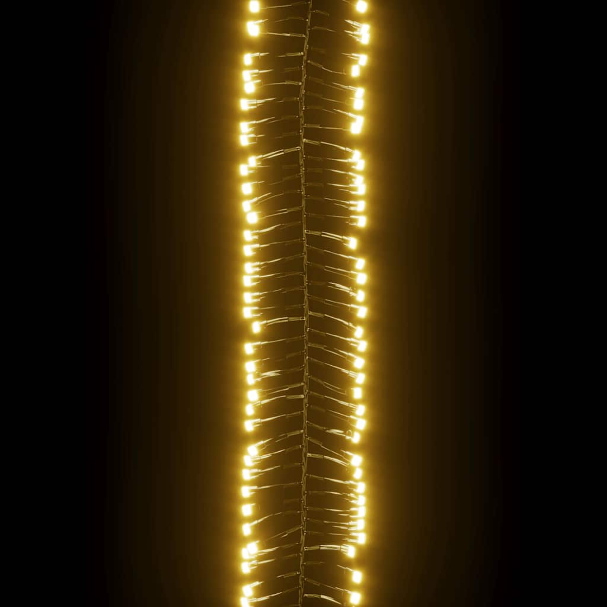 Eine Lichterkette mit warmweißen LEDs vor schwarzem Hintergrund. Die Lichter sind eng beieinander und bilden eine helle vertikale Linie.
