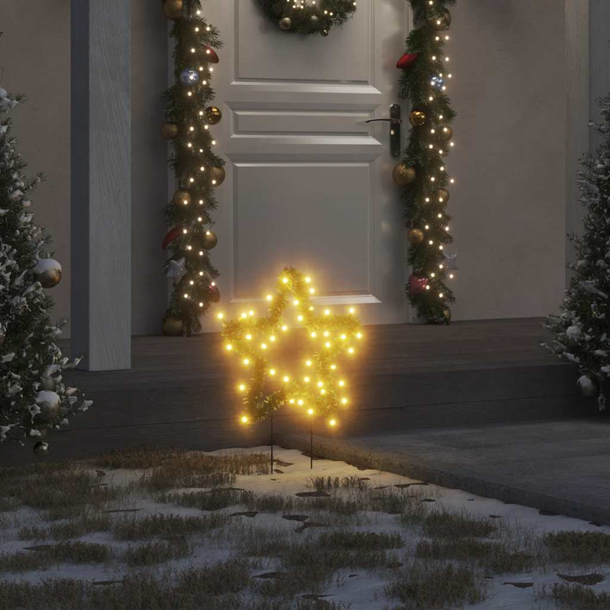 Eine beleuchtete sternförmige Dekoration steht auf einer verschneiten Veranda. Weihnachtsbeleuchtung und Girlanden schmücken die Tür und Bäume.