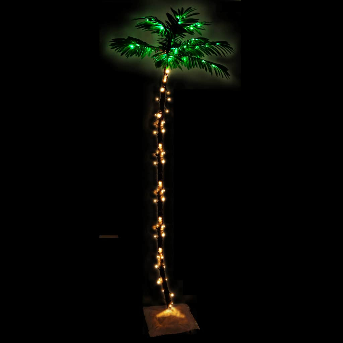 Eine beleuchtete künstliche Palme. Grüne Blätter oben und Lichter am Stamm. Dunkler Hintergrund.
