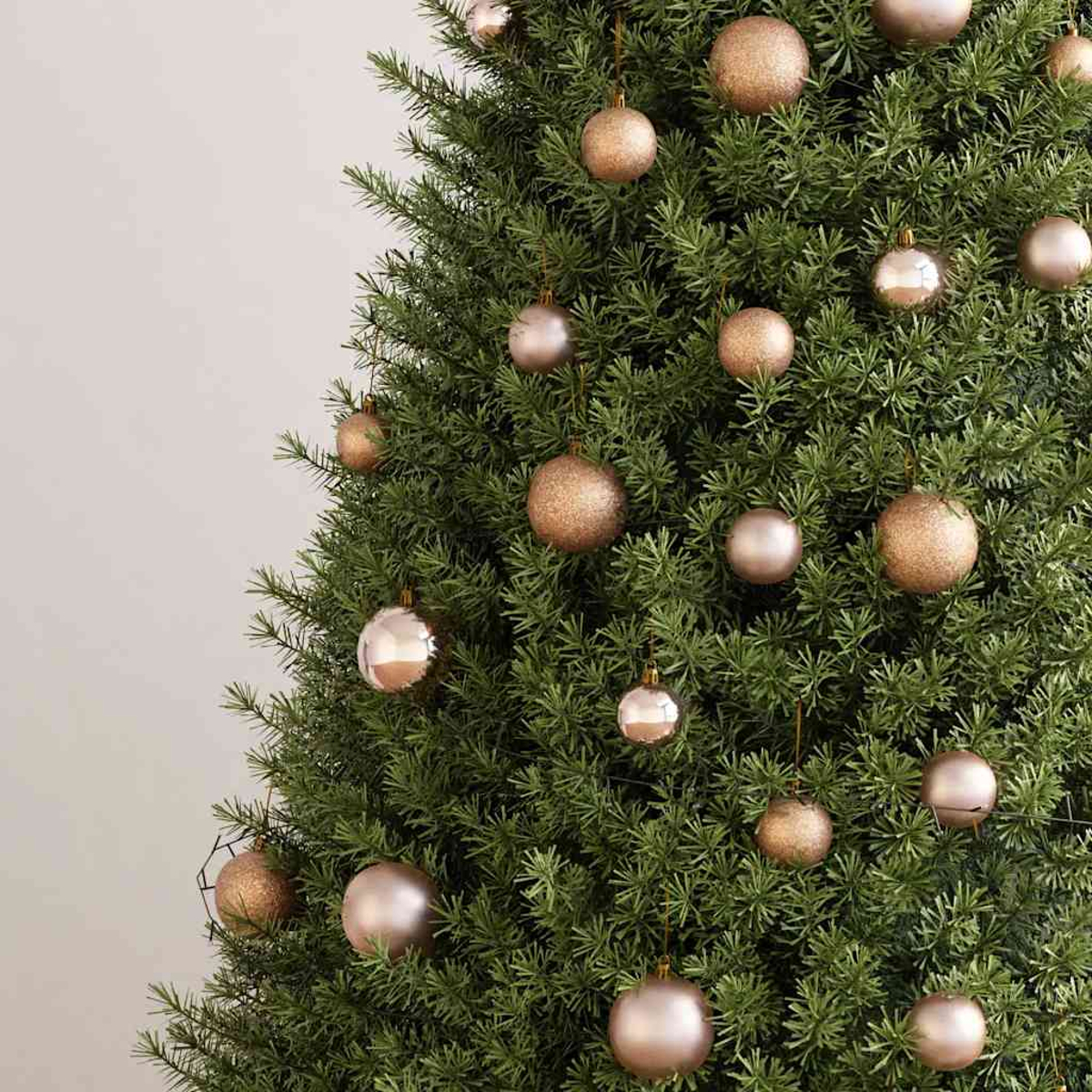 Nahaufnahme eines Weihnachtsbaums mit goldenen und silbernen Ornamenten vor schlichtem Hintergrund. Der Baum ist grün.