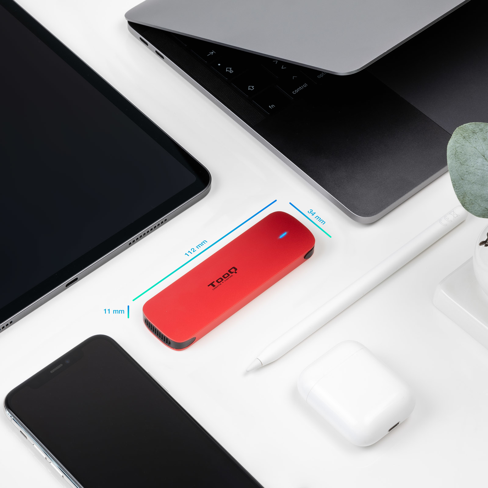 Dispositivo Tooq rojo, tableta, portátil, teléfono, lápiz y estuche AirPods sobre superficie blanca. Se muestran las dimensiones.