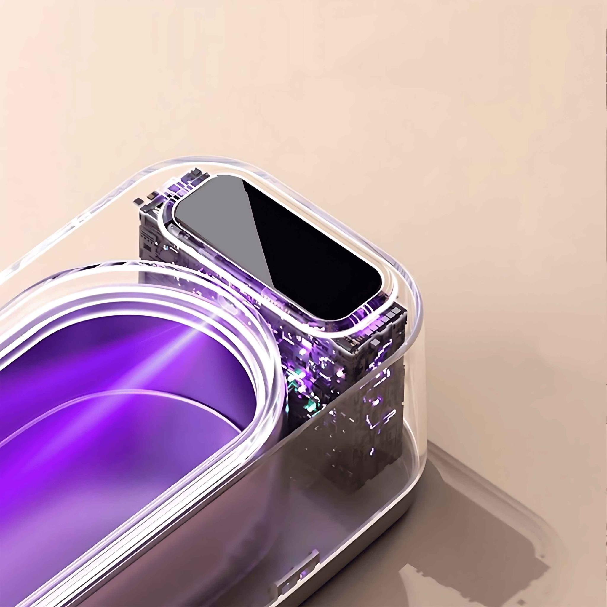 Ein transparentes Gerät mit schwarzem Bildschirm befindet sich in einem violett beleuchteten Behälter. Der Hintergrund ist hellbeige.