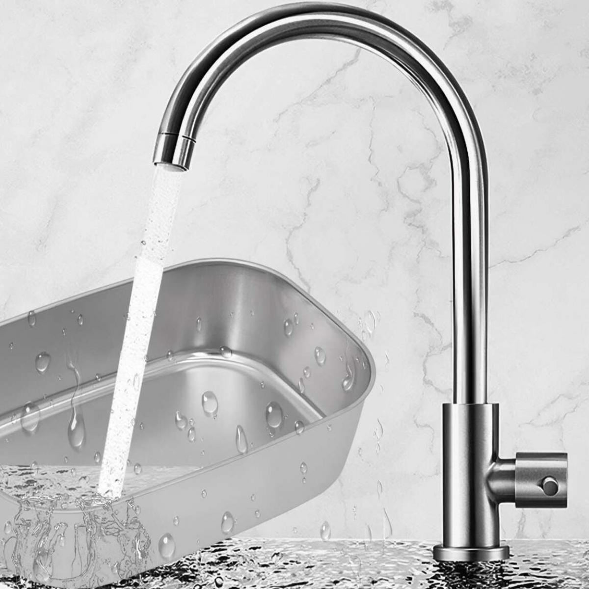 Ein Wasserhahn aus Edelstahl mit Wasser, das in eine Metallschale fließt. Wassertropfen sind auf der Schale und der umliegenden Oberfläche sichtbar. Der Hintergrund ist eine marmorierte Wand.