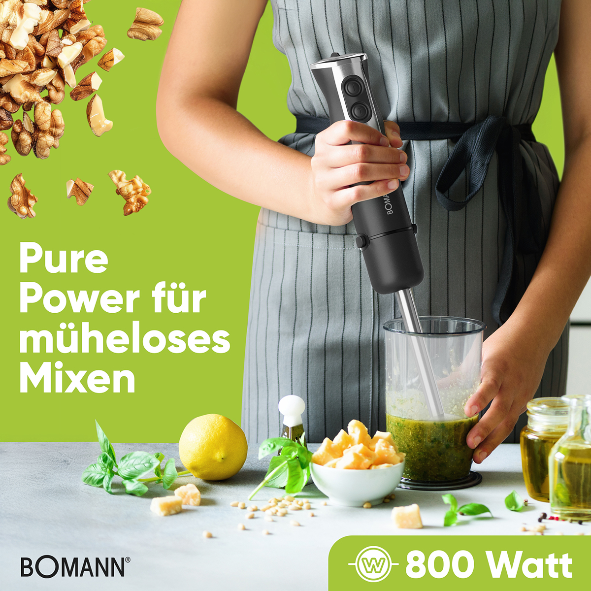 Eine Person mixt Pesto mit einem Stabmixer. Zutaten wie Walnüsse, Zitrone und Käse sind auf einem Tisch. Text: Pure Power.