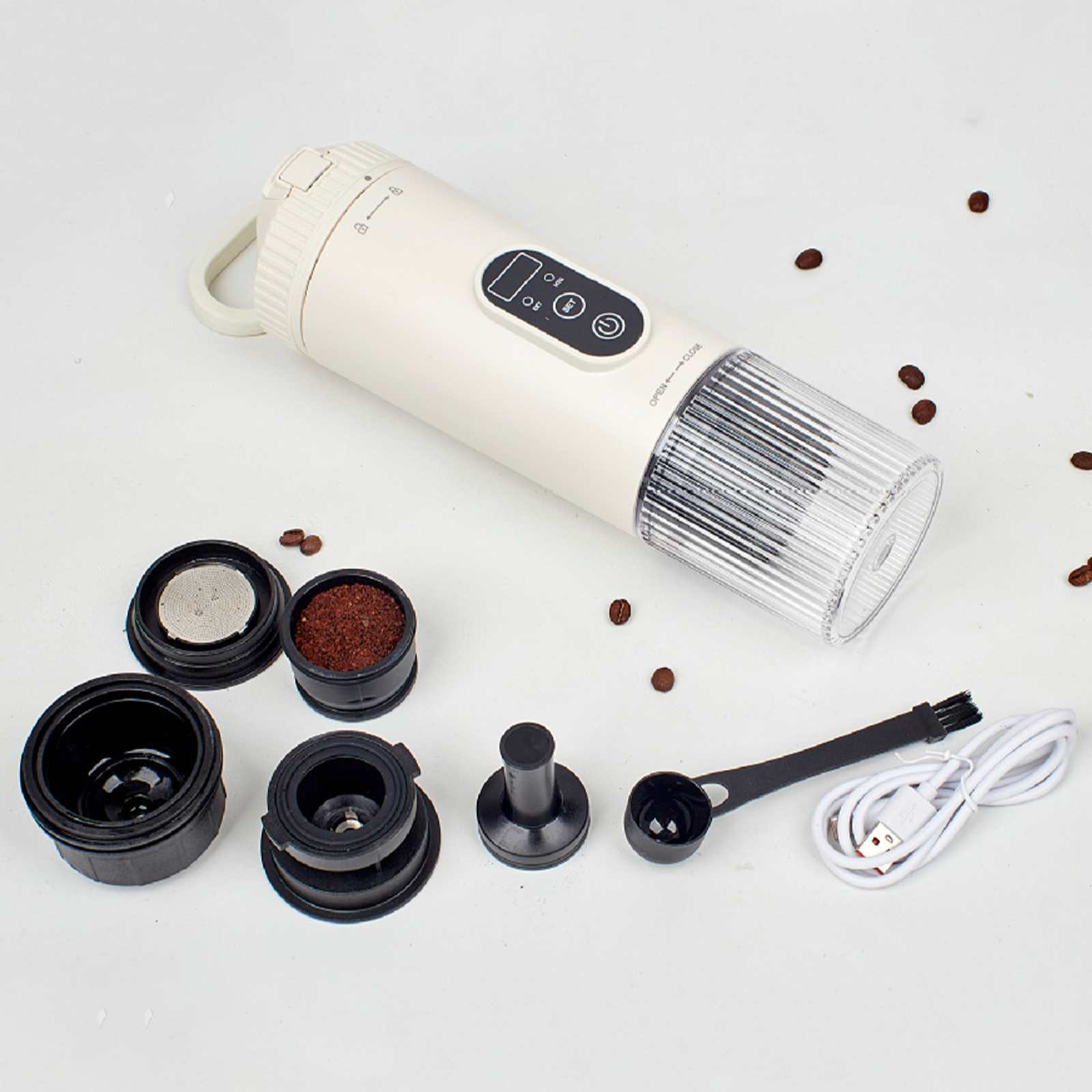 Tragbarer Espressomaker mit Komponenten. Enthält Kaffee, Filter, Bürste, Löffel und USB-Kabel. Verstreute Kaffeebohnen.