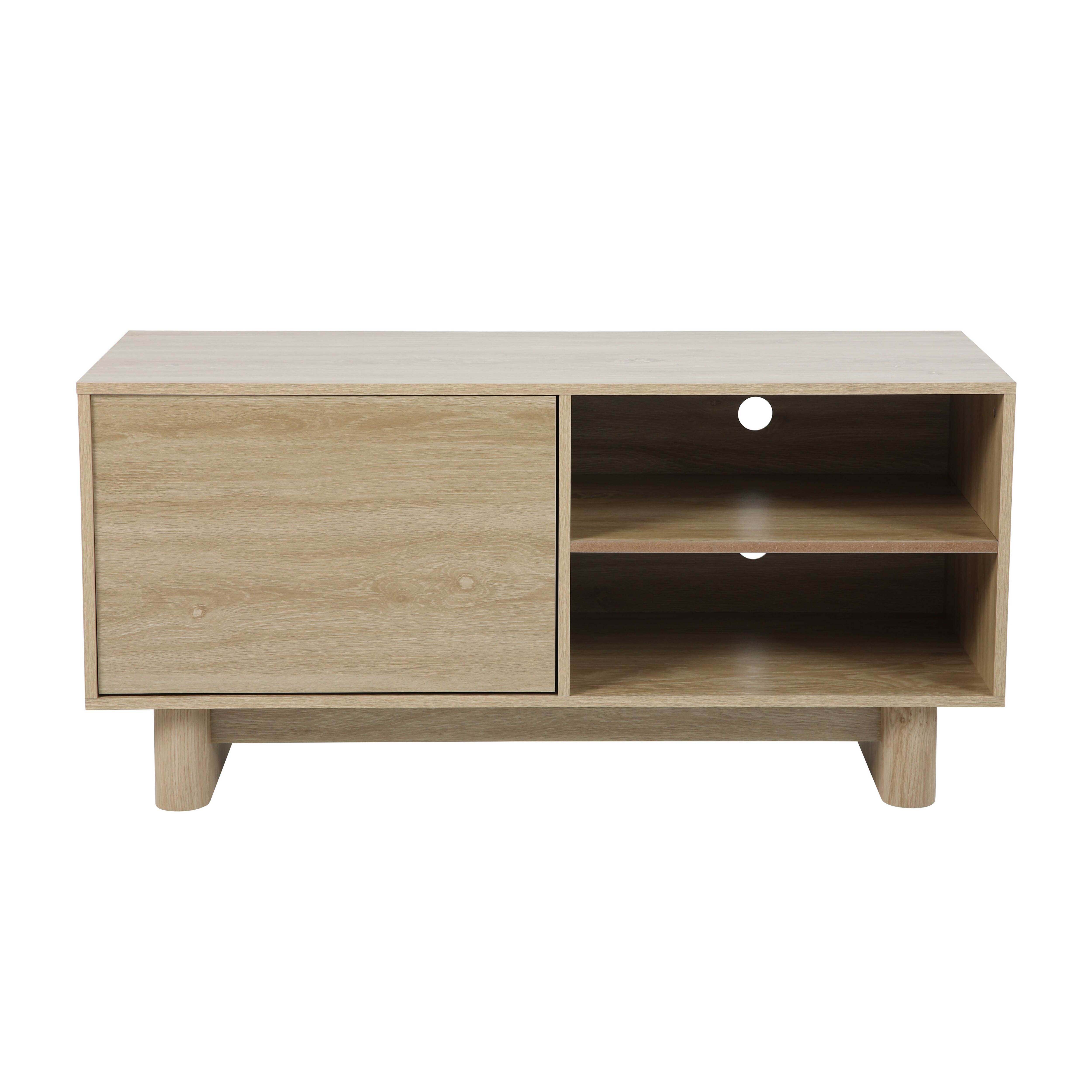 Ein heller TV-Ständer aus Holz mit einer Tür links und offenen Regalen rechts. Es hat runde Beine.