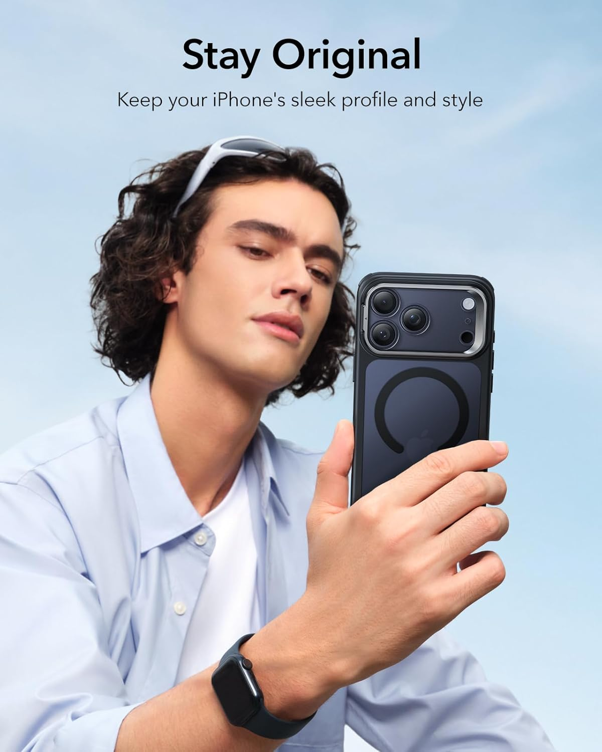 Ein Mann hält ein Telefon in einer Hülle. Der Text 'Stay Original' steht darüber. Er trägt ein hellblaues Hemd, eine Sonnenbrille und eine Uhr.
