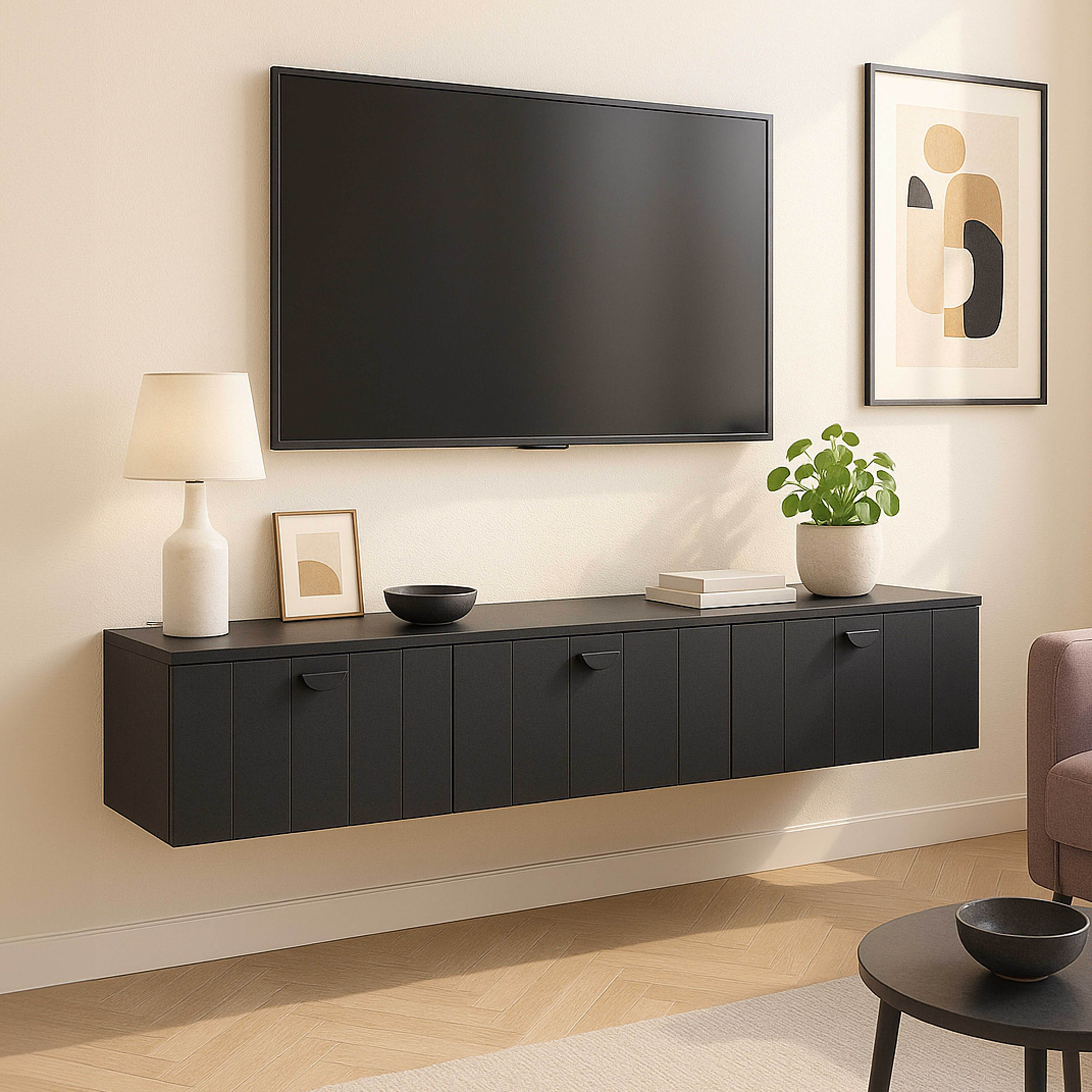 Wohnzimmer mit Fernseher, schwarzem Schrank, Lampe, Kunst und Pflanzen. Schwarzer Tisch mit Schüssel, Sofa.