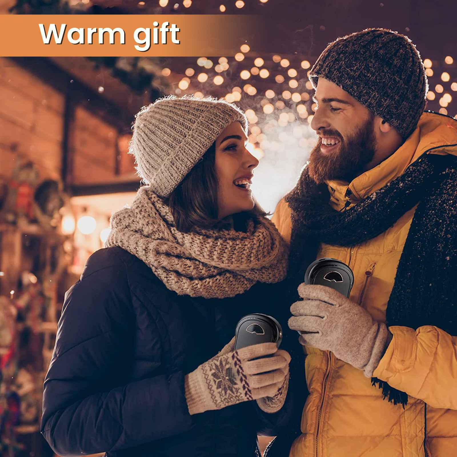 Ein lächelndes Paar hält Handwärmer. Sie tragen Winterkleidung, im Hintergrund verschwommene Lichter. Der Text "Warmes Geschenk" steht darüber.