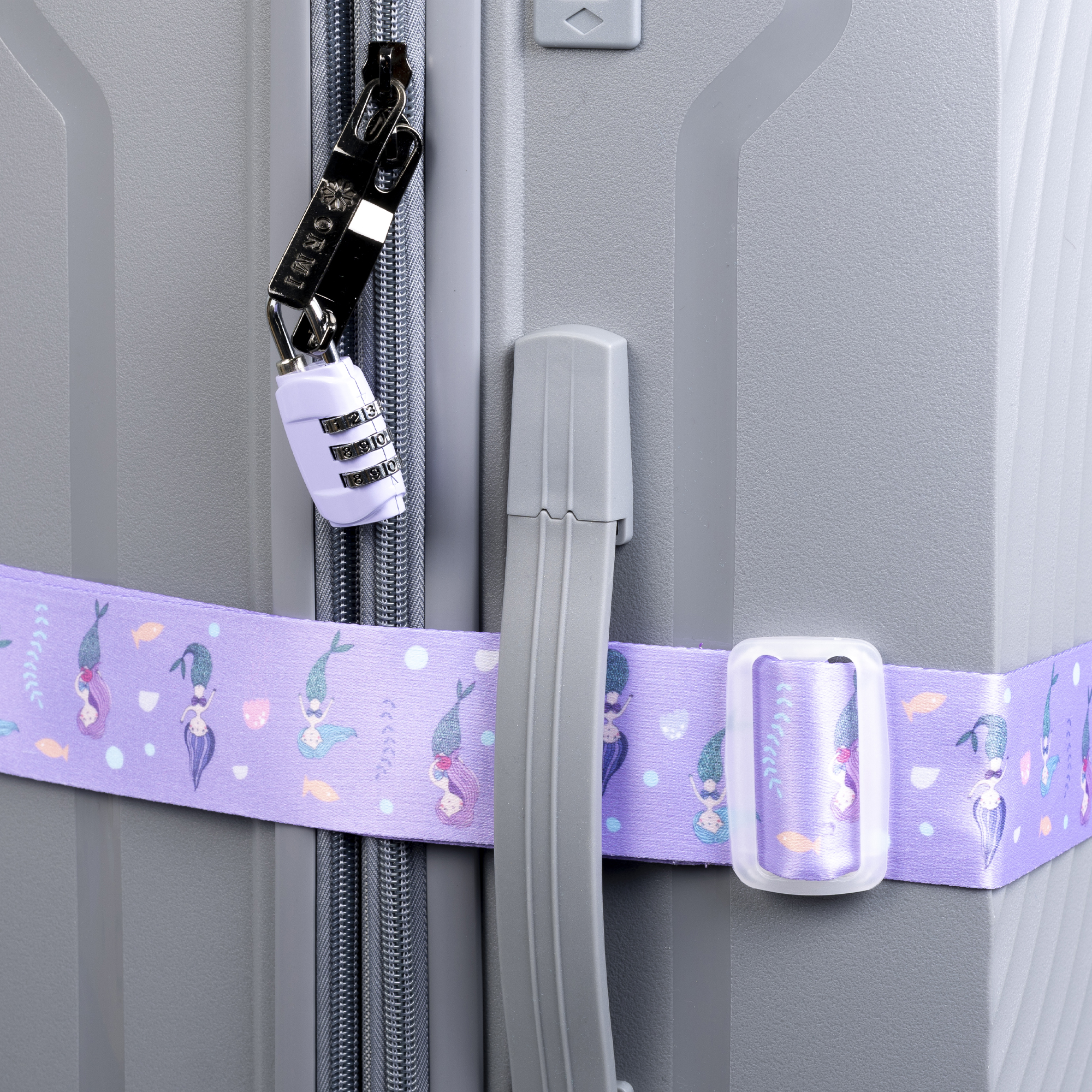 Primer plano de una maleta gris con cerradura de combinación y una correa con estampado de sirenas.