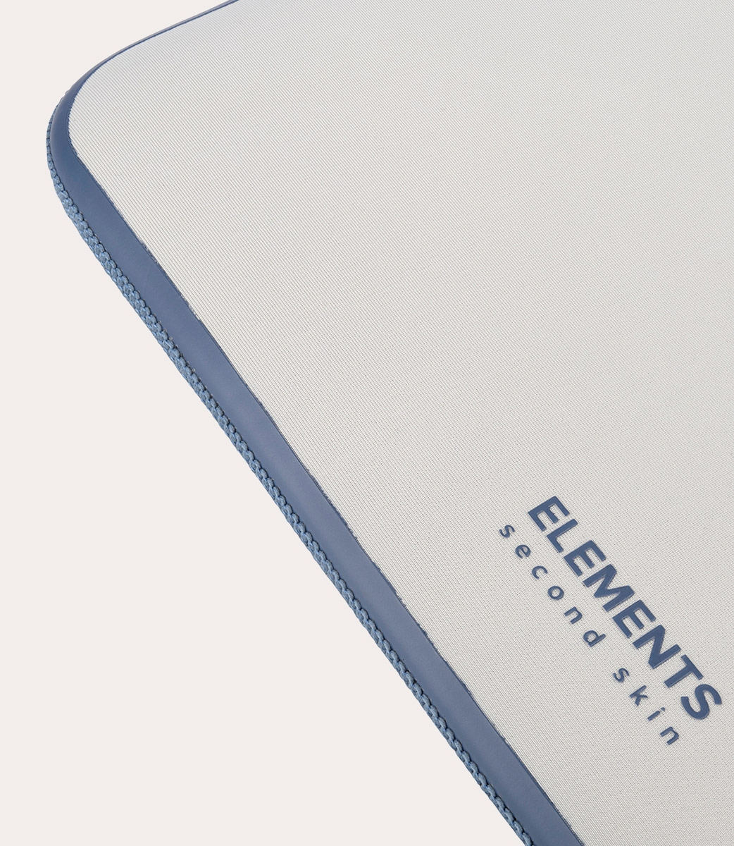 Nahaufnahme einer weißen, strukturierten Oberfläche mit blauem Rand. Der Text 'ELEMENTS second skin' ist sichtbar.