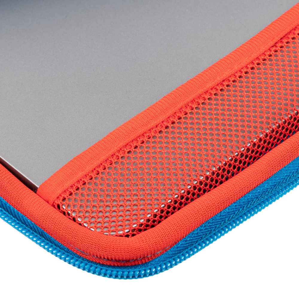 Nahaufnahme einer Ecke einer Laptoptasche. Sie hat einen blauen Reißverschluss, rotes Netz und Zierleisten sowie eine graue Laptopoberfläche.