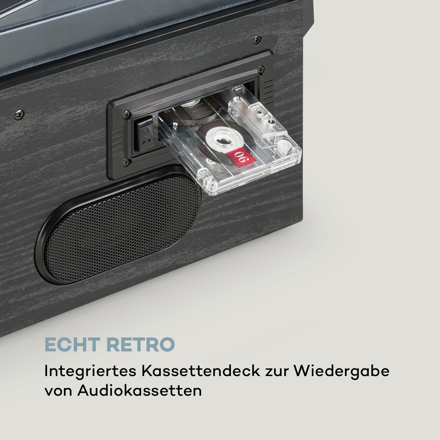 Nahaufnahme eines schwarzen Retro-Musikplayers mit eingelegter Kassette. Ein Lautsprecher und Text sind sichtbar.