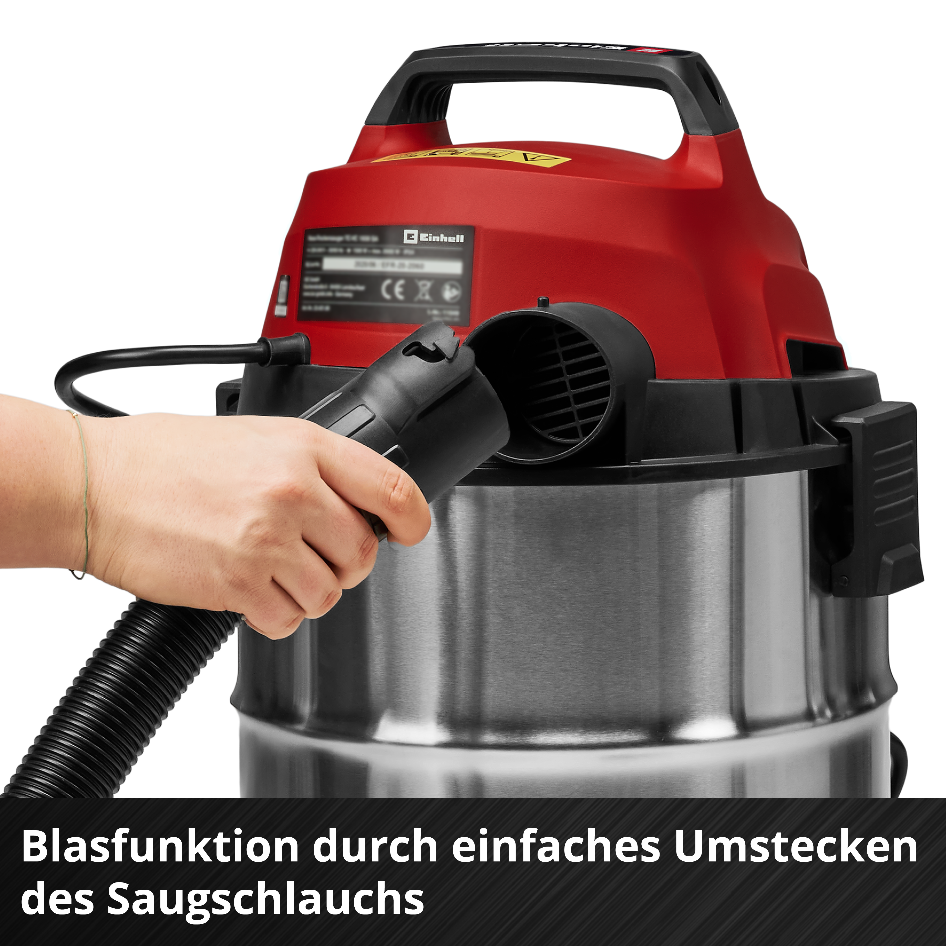 Mano che tiene un tubo nero a un aspirapolvere rosso e acciaio. Il testo dice 'Blasfunktion durch...'