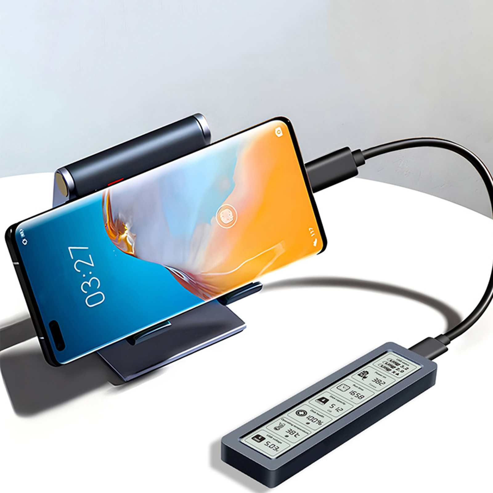 Ein Telefon wird auf einem Ständer aufgeladen und ist über ein schwarzes Kabel mit einem kleinen Display verbunden.