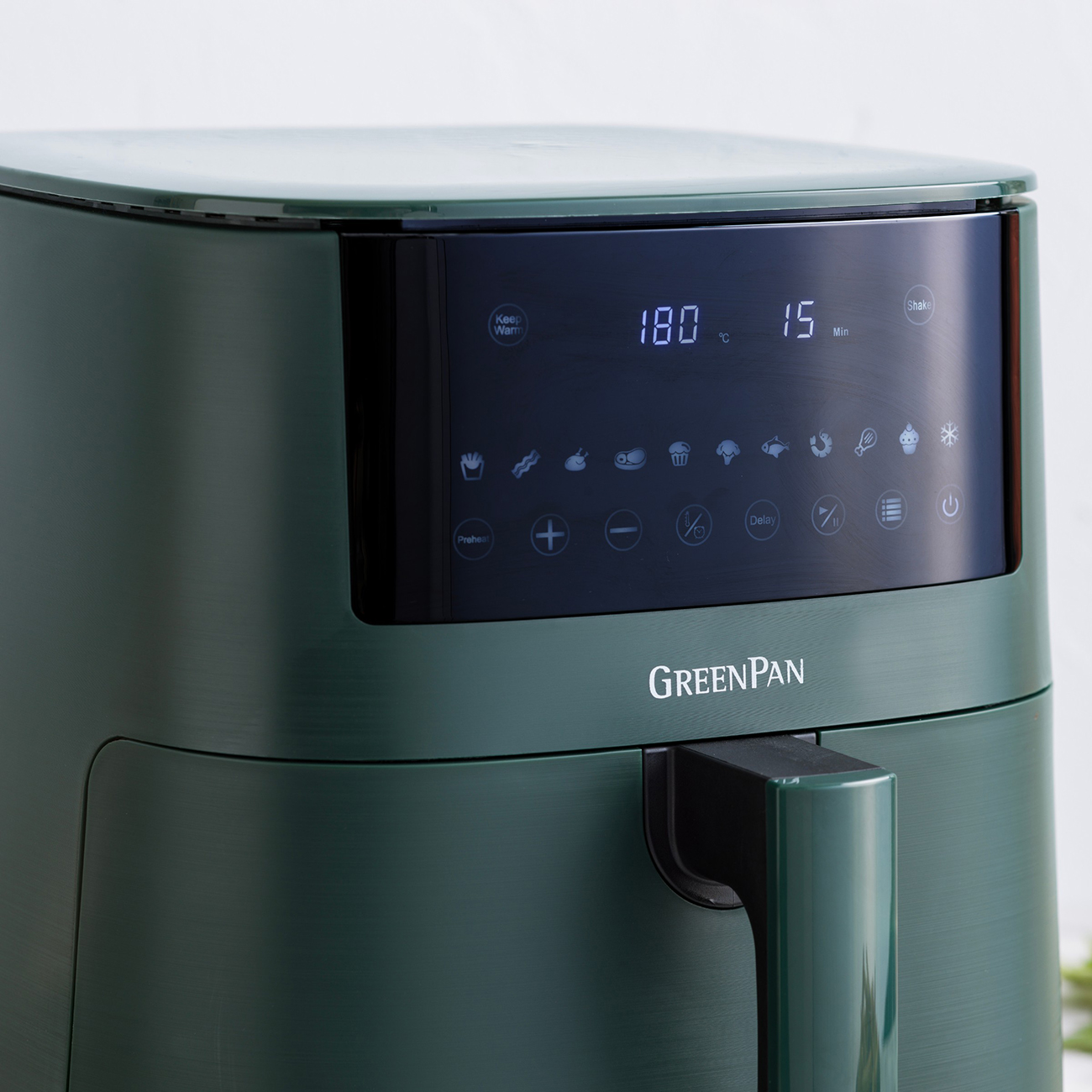 Ein dunkelgrüner GreenPan-Luftfritteuse. Das Display zeigt 180 Grad und 15 Minuten. Es hat einen Griff und verschiedene Funktionssymbole.