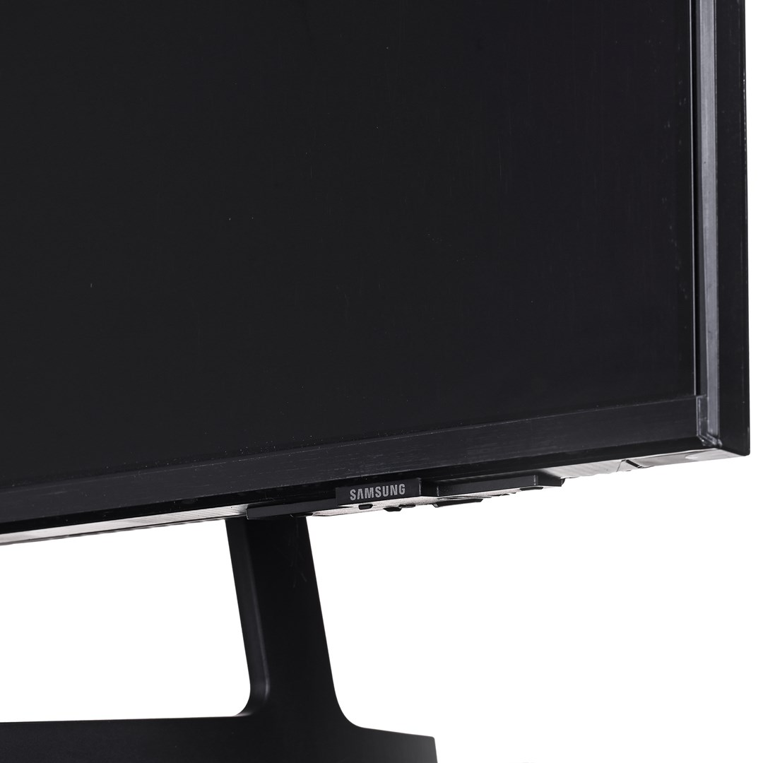Primo piano di un monitor di computer Samsung nero su sfondo bianco. Anche la base e il supporto del monitor sono neri.