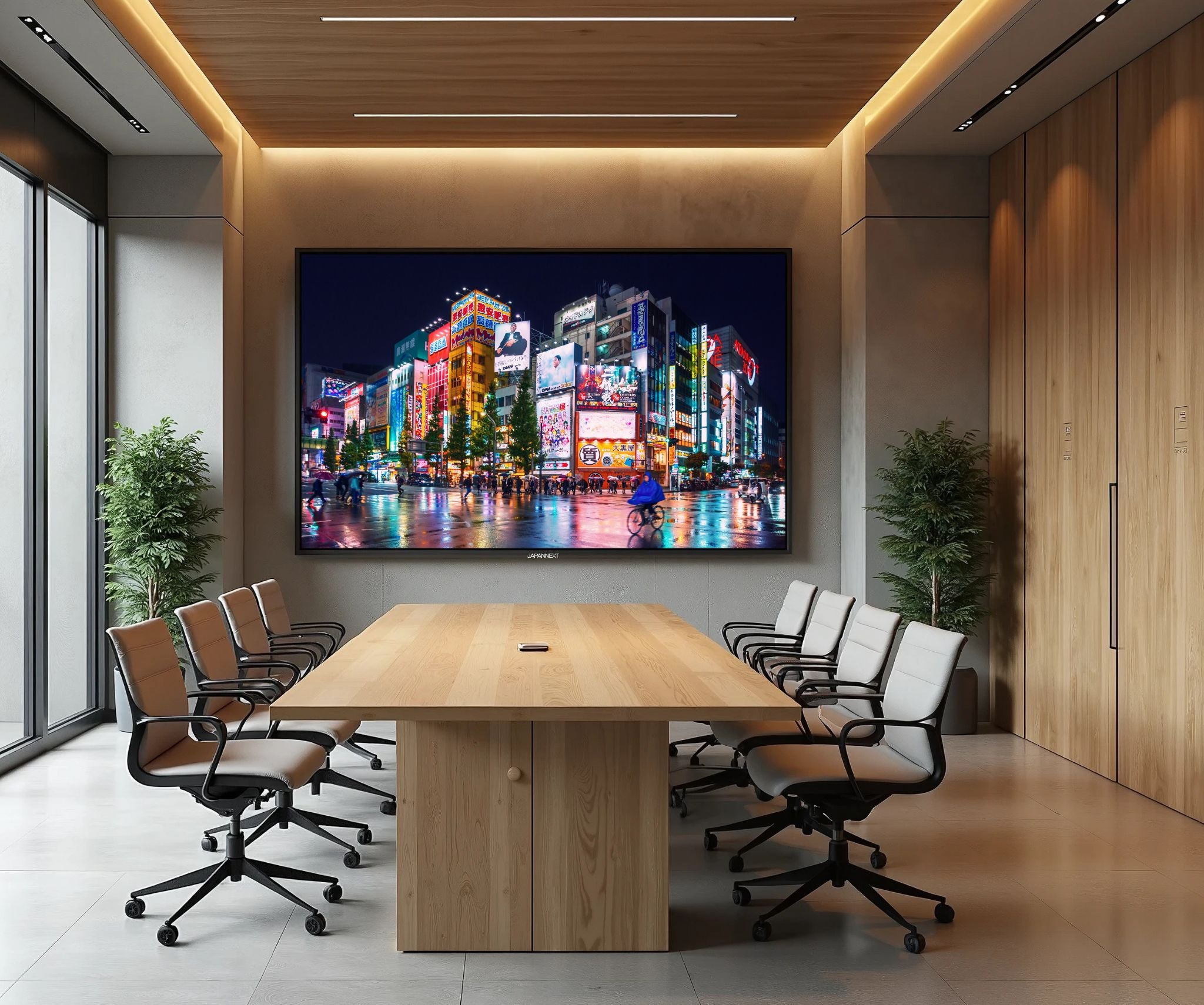 Una sala de conferencias con una gran pantalla que muestra una ciudad de noche. Mesas y sillas están preparadas para una reunión.