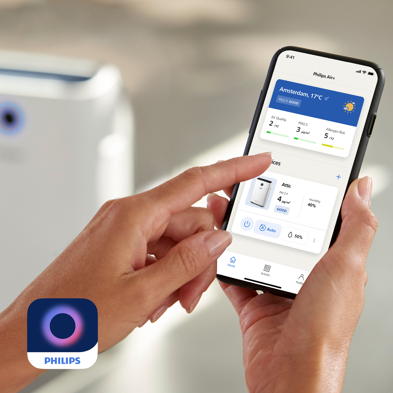 Una persona tiene in mano un telefono con l'app Philips Air+. Lo schermo mostra i dati sulla qualità dell'aria e i controlli.