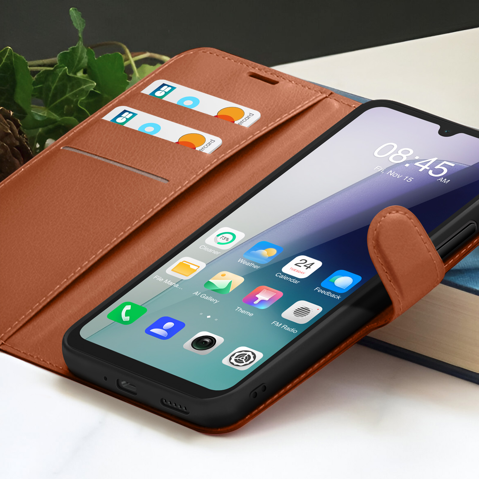 Un smartphone dans un étui en cuir marron affiche l'heure et les icônes d'applications. Cartes de crédit dans une fente. Un livre en arrière-plan.