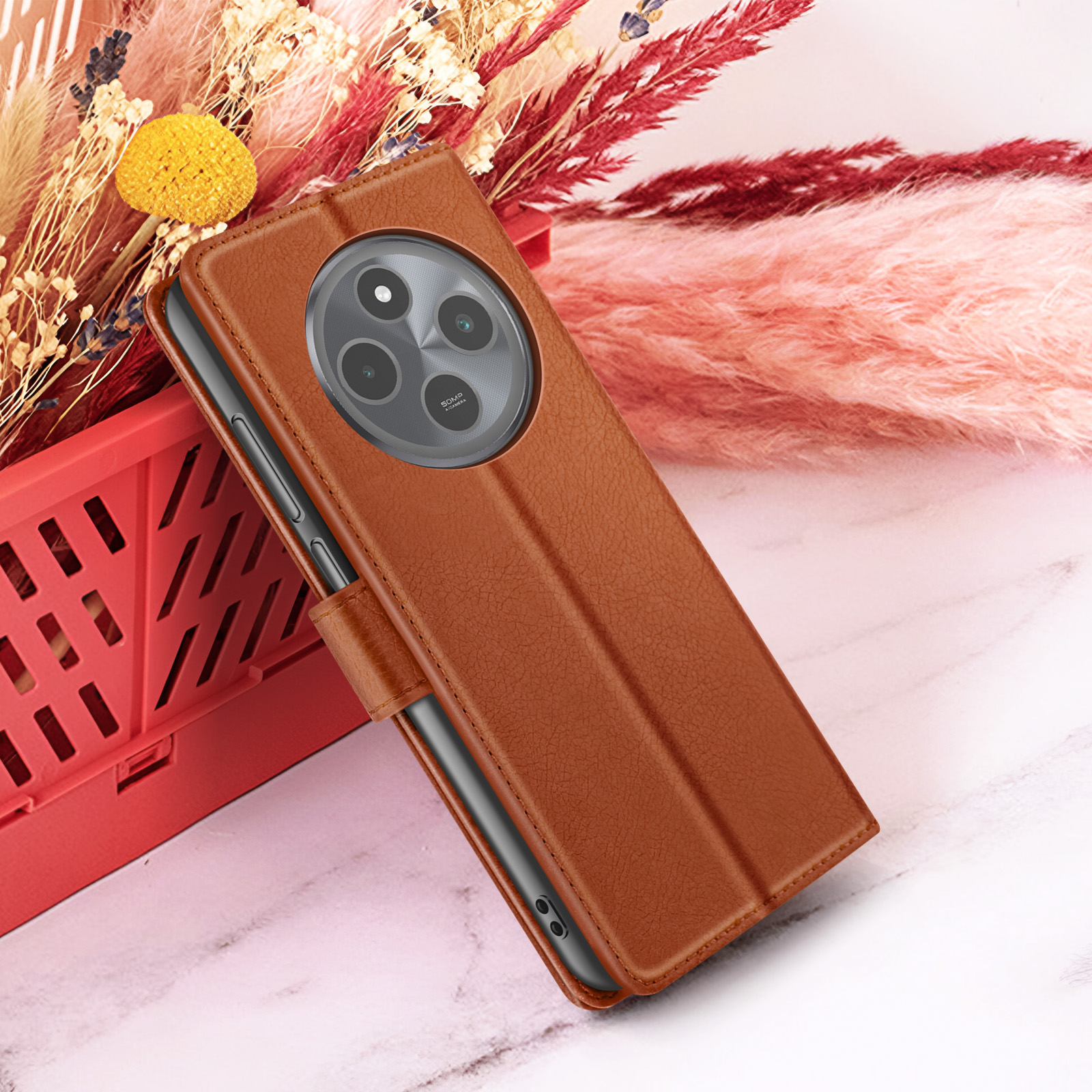 Étui de téléphone marron avec caméra. Récipient rouge avec des fleurs et fond blanc. L'étui est ouvert.