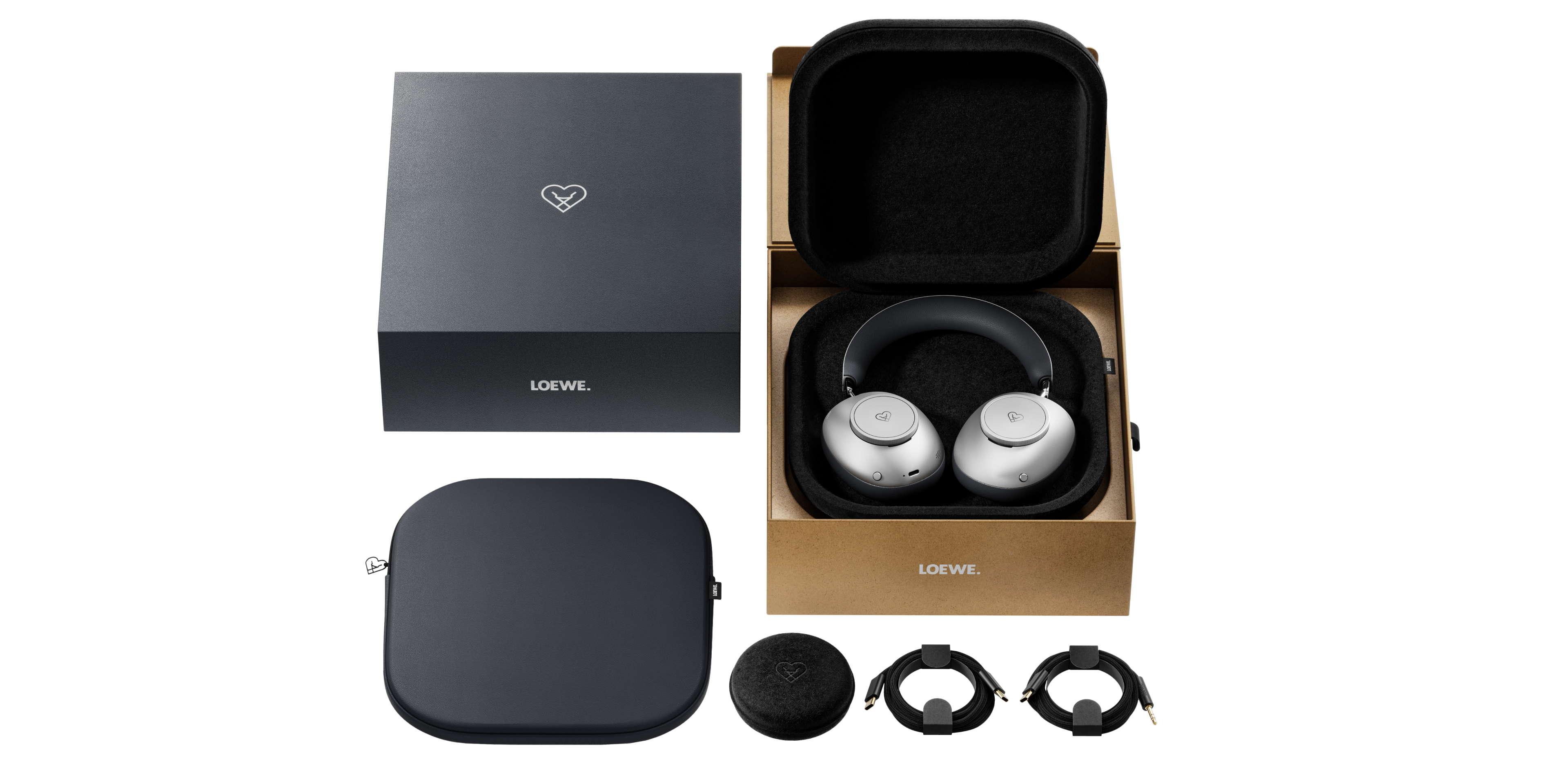 Ein Loewe-Kopfhörer-Set. Enthält Kopfhörer, eine Hülle und Kabel. Die Kopfhörer sind silberfarben, die Box und die Hülle sind schwarz.