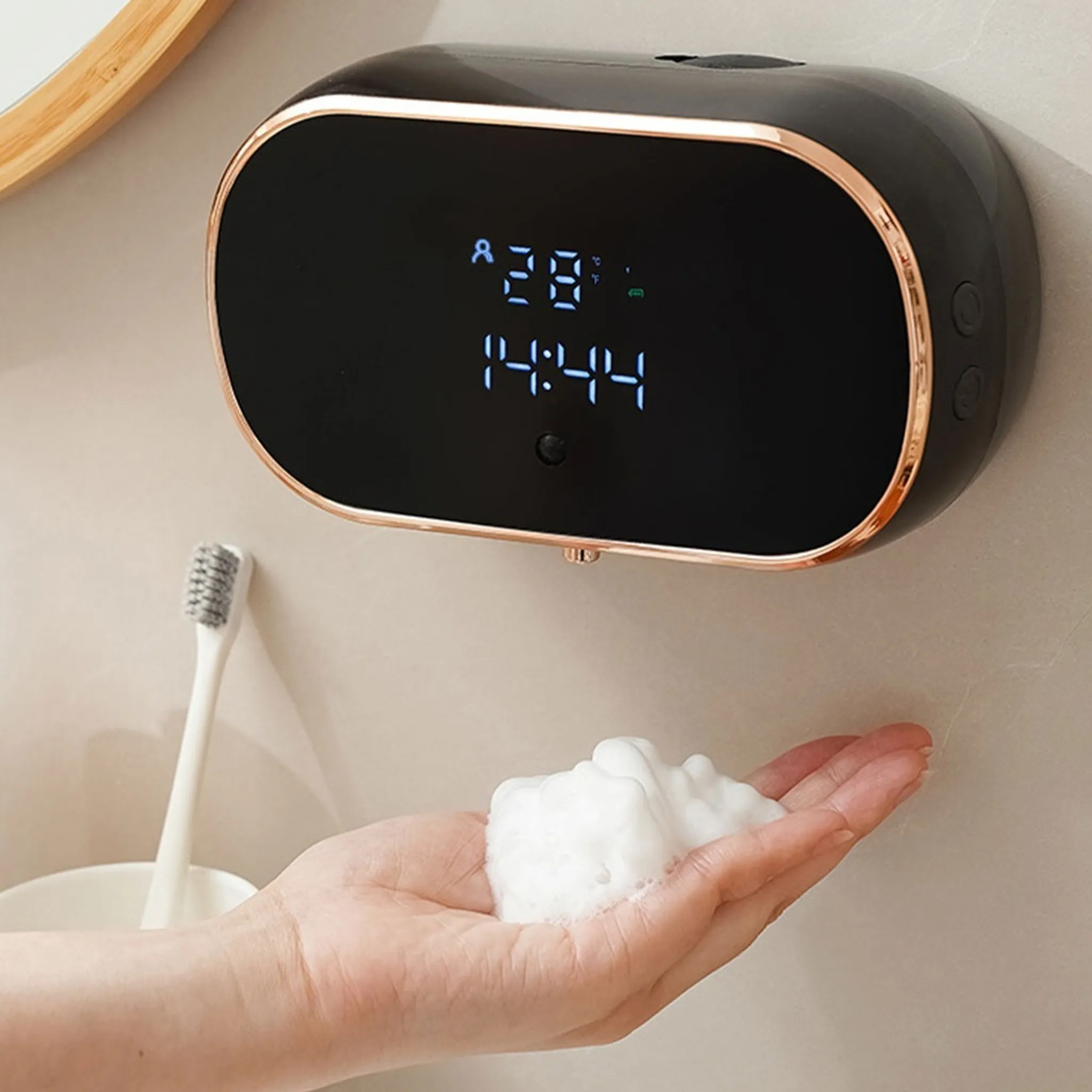 Ein schwarzer Seifenspender mit digitaler Anzeige zeigt Zeit und Temperatur. Eine Hand hält Schaum.
