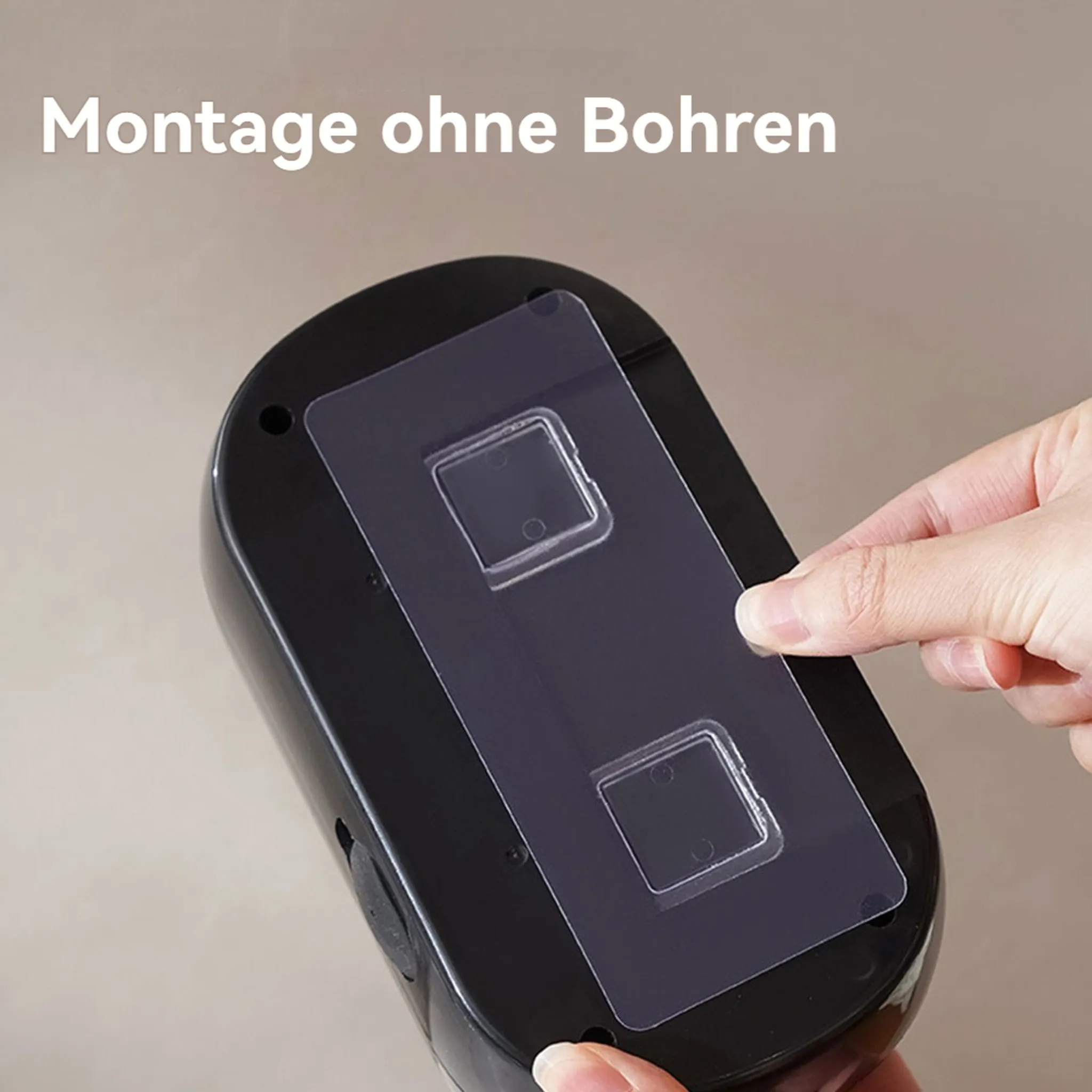 Eine Hand drückt ein klares Klebepad auf ein schwarzes Objekt. Text "Montage ohne Bohren" ist sichtbar.