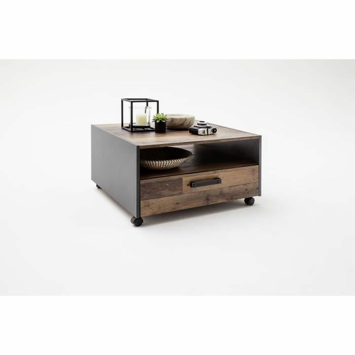 Ein Couchtisch aus Holz mit Schublade, schwarzem Metallrahmen und Rollen. Oben befinden sich Dekorationsgegenstände.