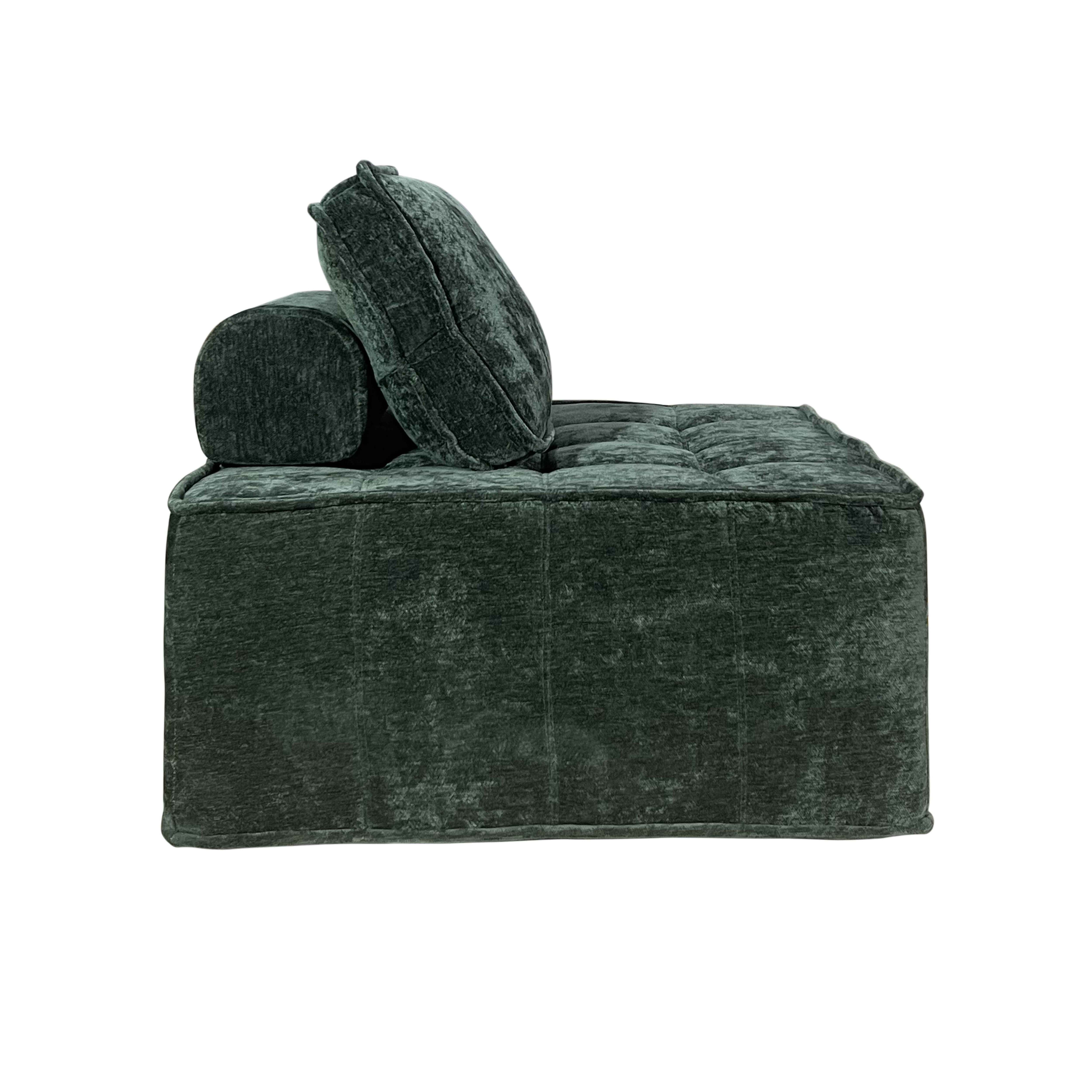 Ein dunkelgrünes, getuftetes, gepolstertes Sofa mit einer Rolle und einem Kissen, vor weißem Hintergrund.