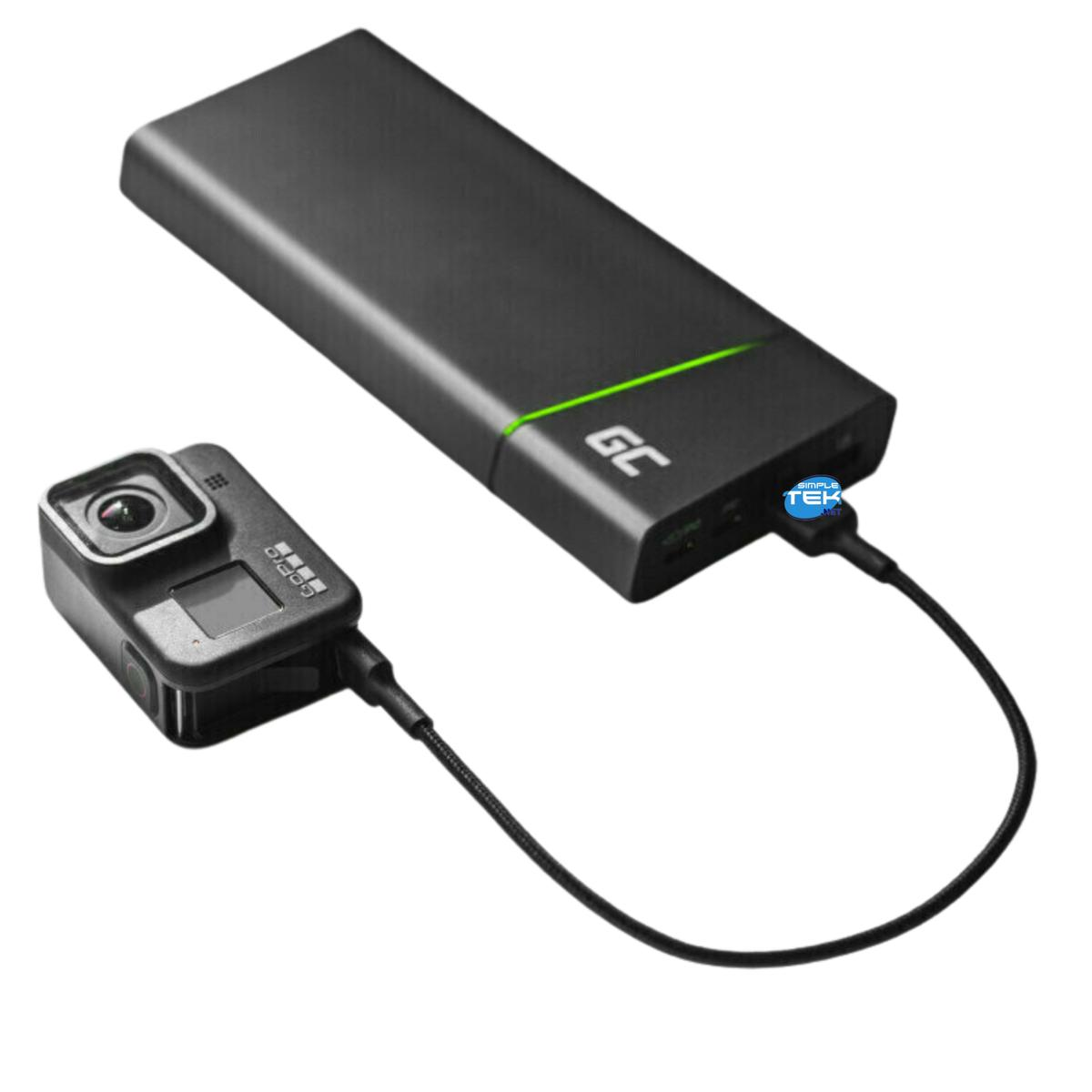 Una fotocamera GoPro nera è collegata a un power bank nero tramite un cavo nero. Il power bank ha una luce verde.