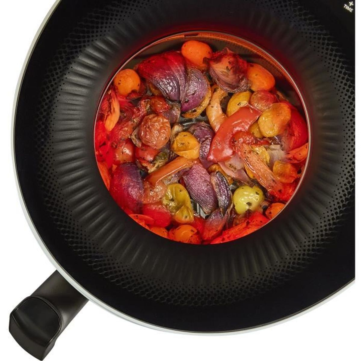 Widok z góry na patelnię z pieczonymi warzywami. W środku są czerwone, żółte i fioletowe warzywa. Patelnia jest czarna, z uchwytem.