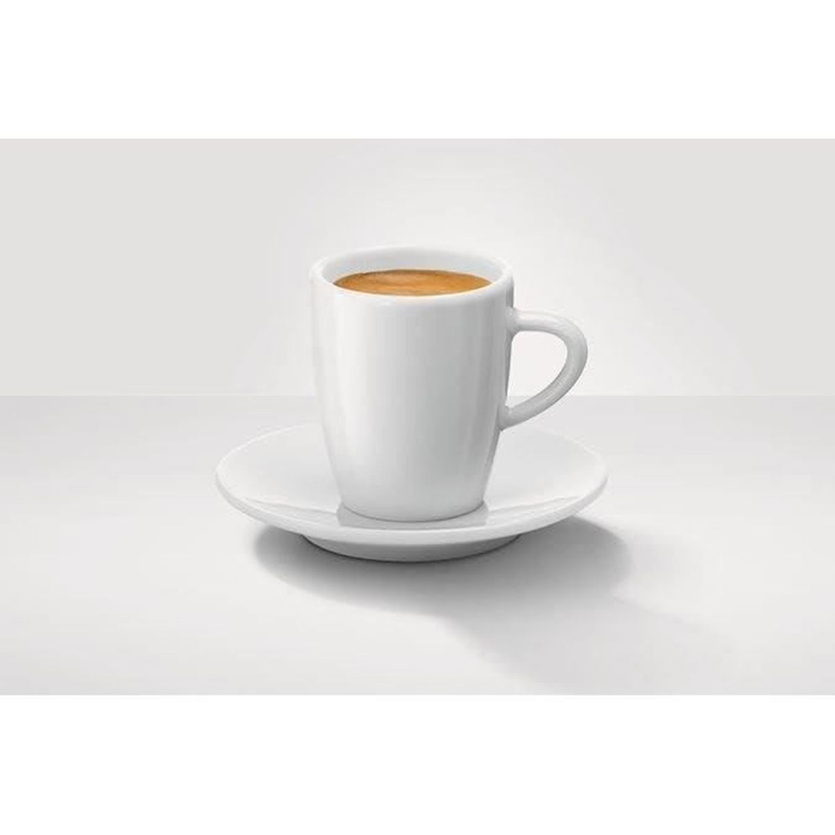 Una taza de café blanca con café marrón se encuentra sobre un platillo blanco. El fondo es blanco.