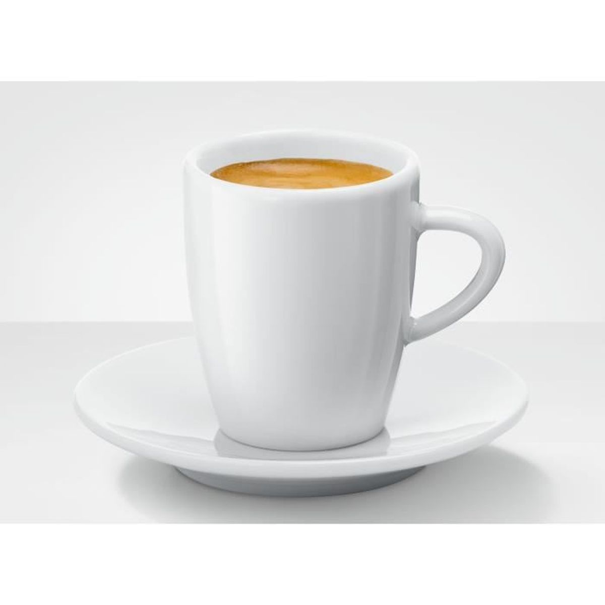 Una taza de café blanca sobre un platillo, llena de café. La taza tiene un asa. El fondo es blanco.