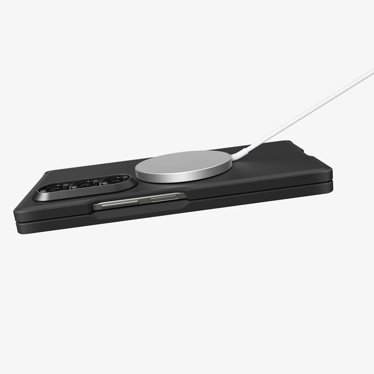 Un téléphone pliable noir avec un chargeur sans fil argenté. Un câble blanc relie le chargeur. Le fond est blanc.