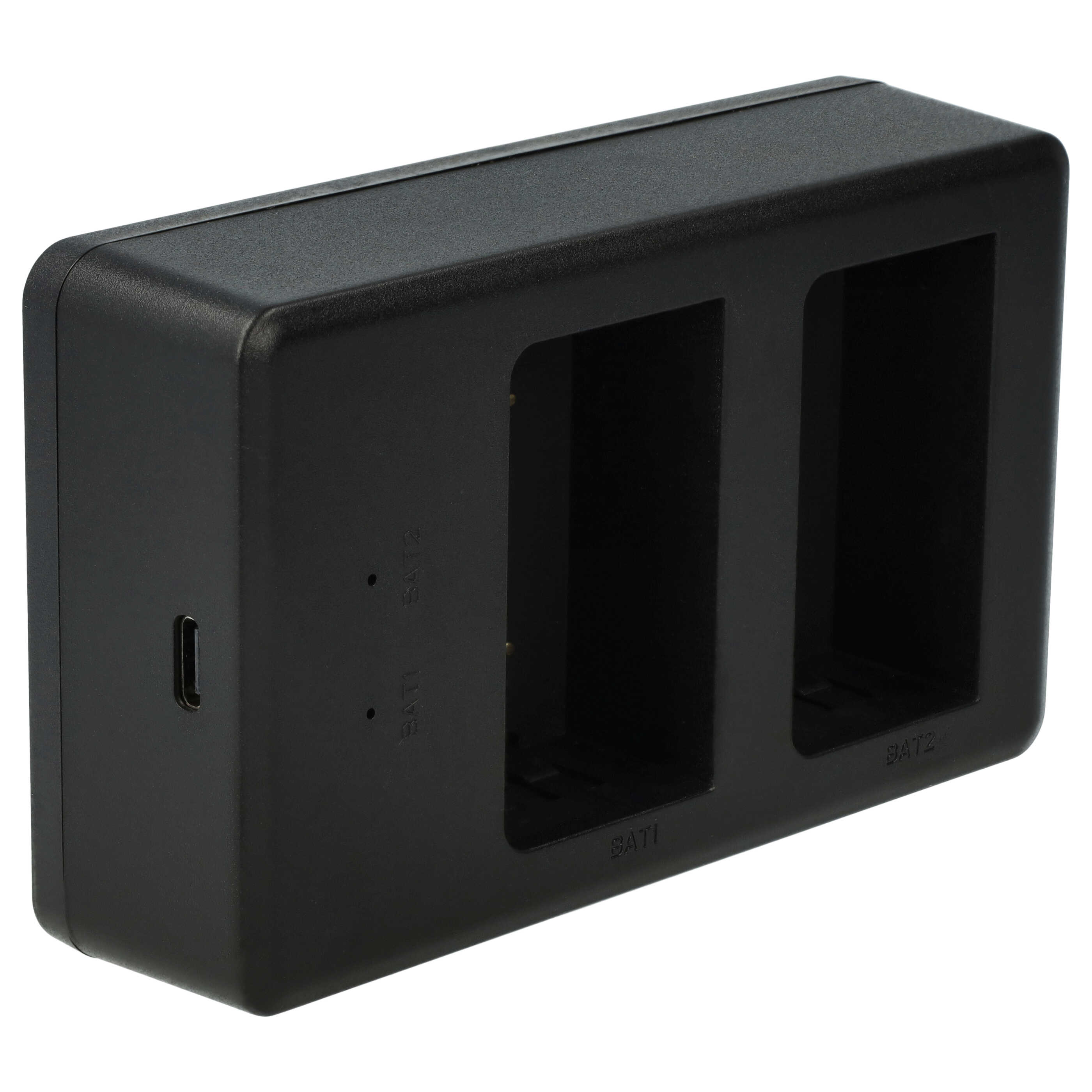 Ein schwarzes Batterieladegerät mit zwei Schlitzen, beschriftet mit BAT1 und BAT2, auf weißem Hintergrund.