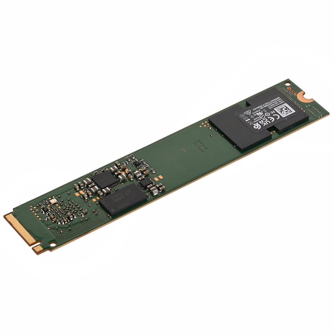 Un circuito stampato verde con chip e connettori. È un componente elettronico, probabilmente un'unità SSD.