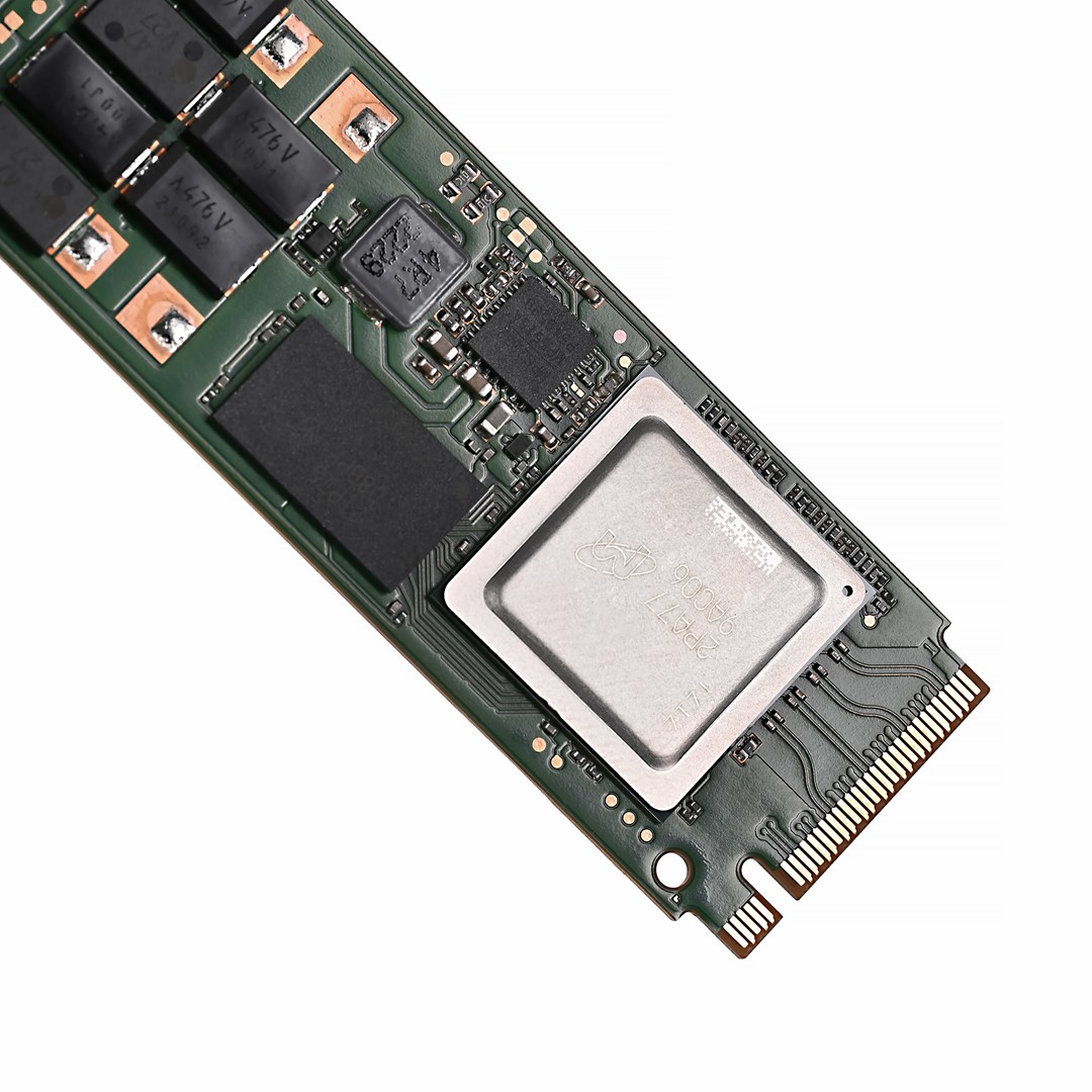 Un circuito stampato verde con vari componenti elettronici. È visibile un grande chip quadrato argentato, insieme a chip neri più piccoli.